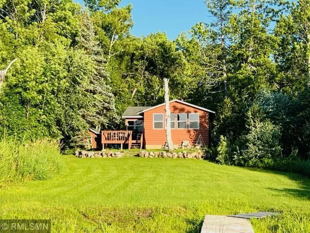 Cabin from lake on sunny day