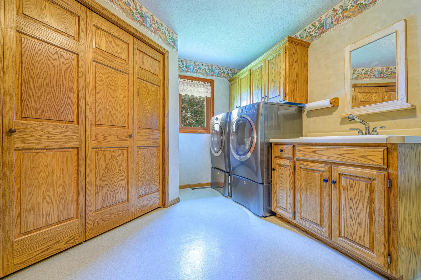 The main floor laundry room features oak cabinets for additional storage. The kitchen pantry closet is also located in this room.