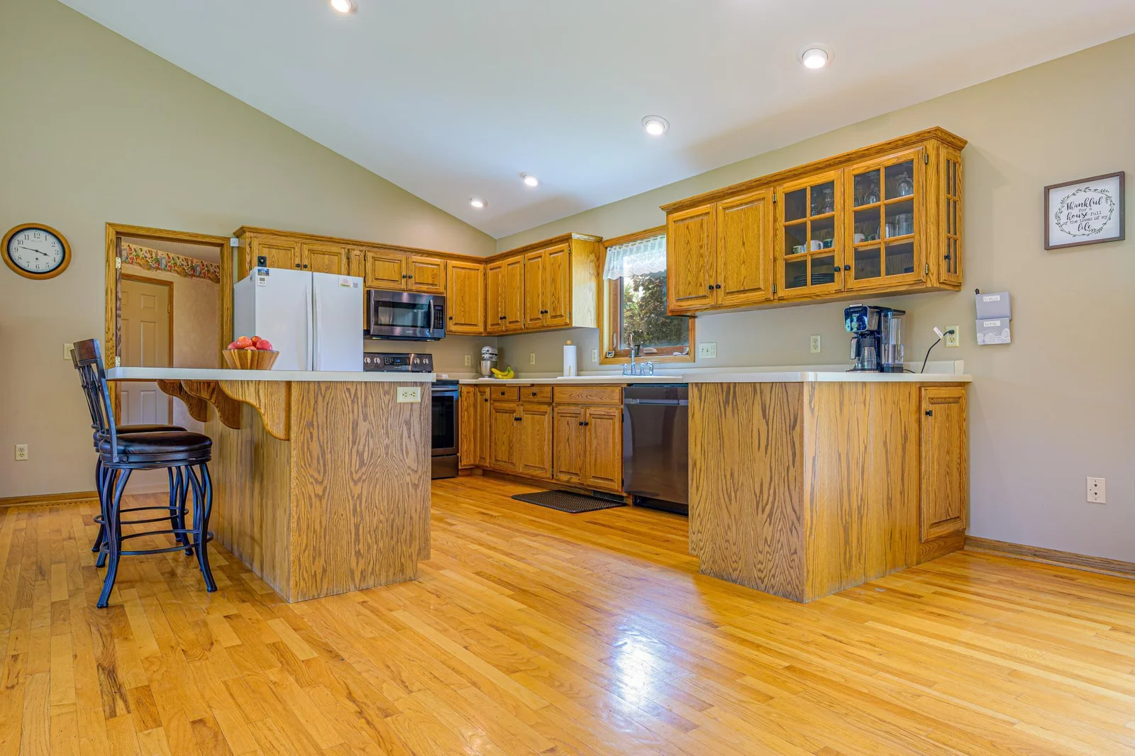 The kitchen features hardwood floors, oak wood cabinets, a center island, and a garbage disposal.