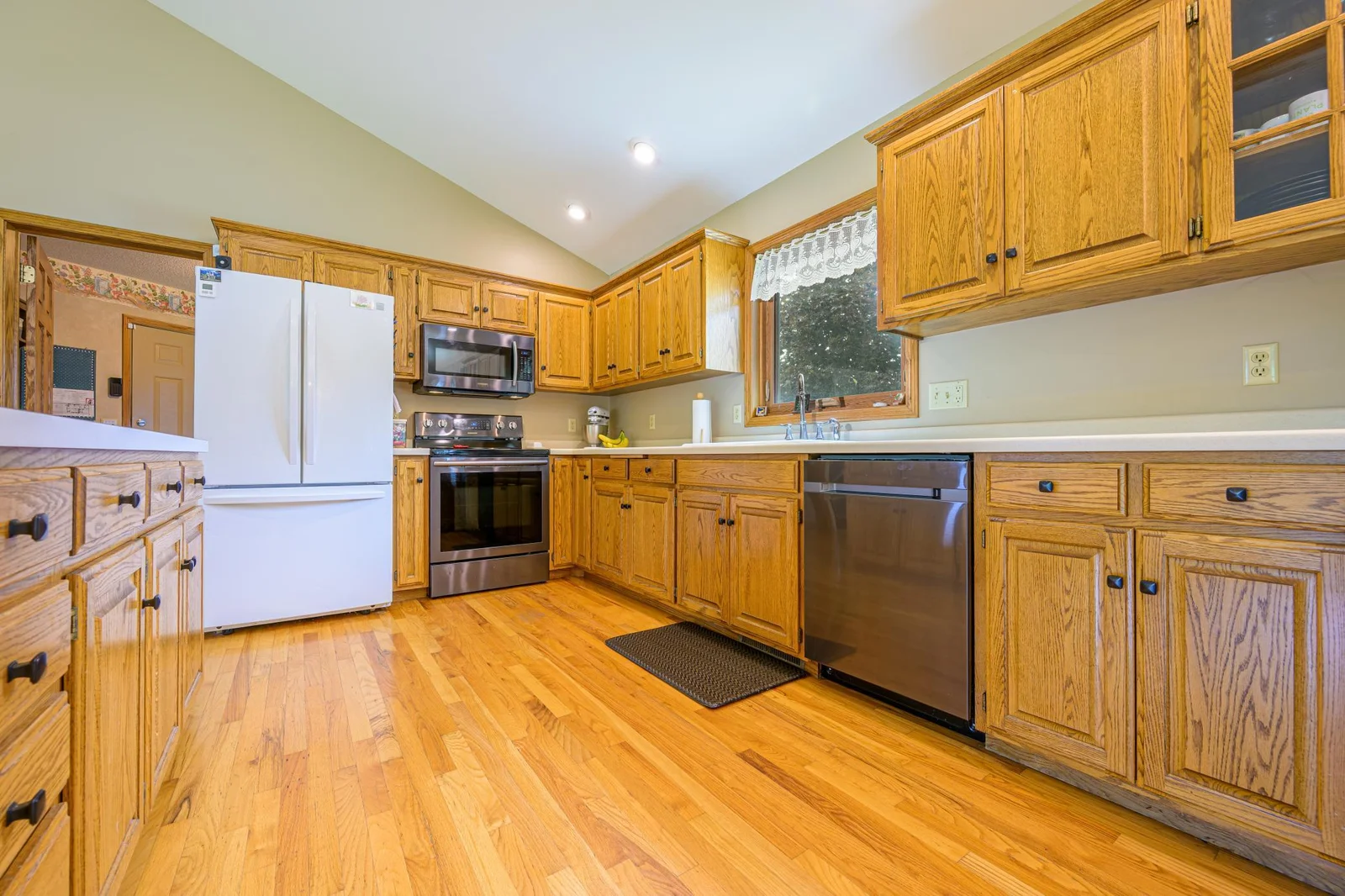 The kitchen features hardwood floors, oak wood cabinets, a center island, and a garbage disposal.