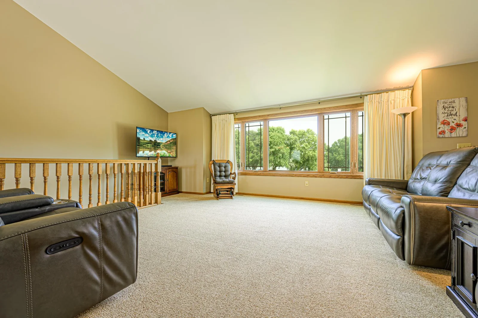 The living room features vaulted ceilings and large windows to allow in plenty of natural light.