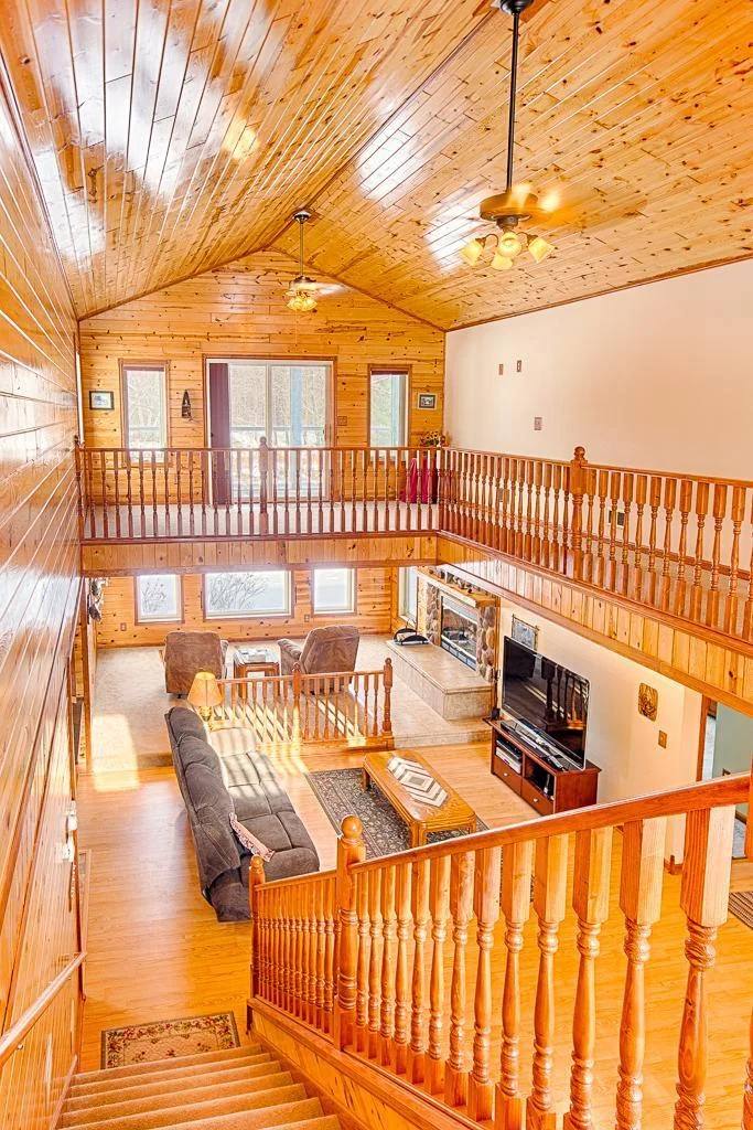 A view looking down the stairs to the 2-tiered living room space.