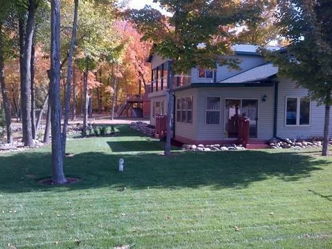 Another pristine yard view showing the lush landscaping and park like setting treed lot...