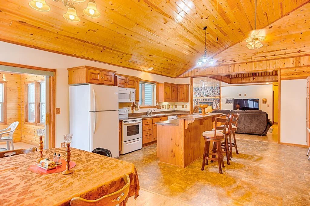 A dining room to kitchen to living room view with the 3-season porch at the left in this photo.