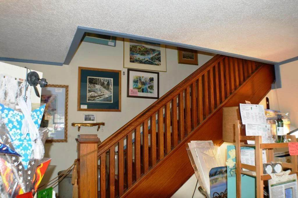 Craftman solid wood staircase leads to owner's suite above.