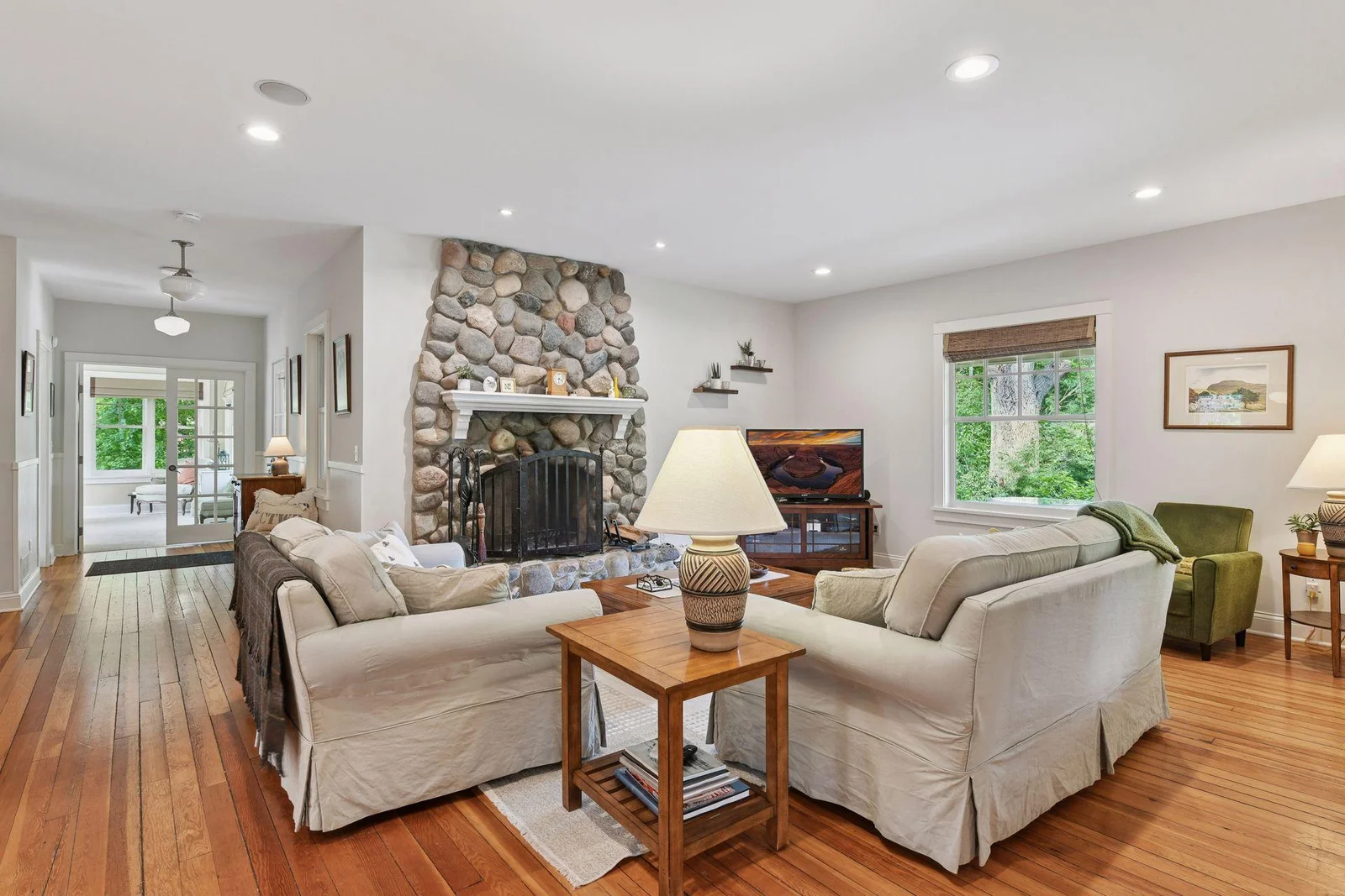 Cozy main floor living room with wood burning fireplace and wood floors