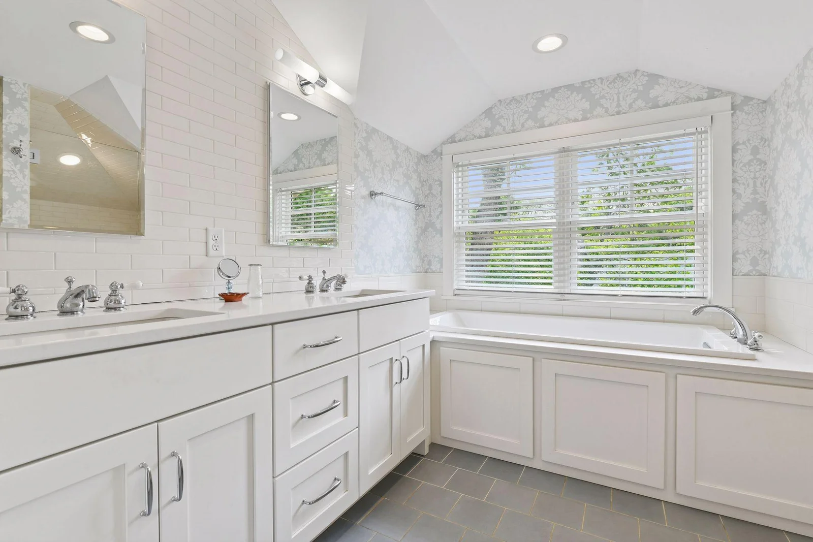Primary bathroom ensuite with double vanity, tile floor and natural light