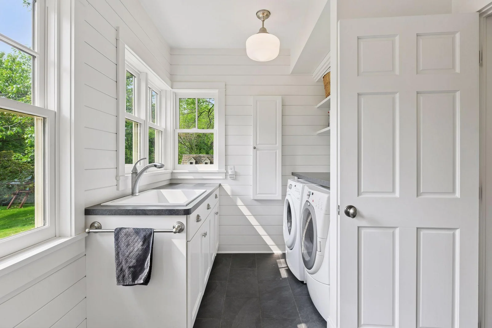 Main floor laundry with sink and storage