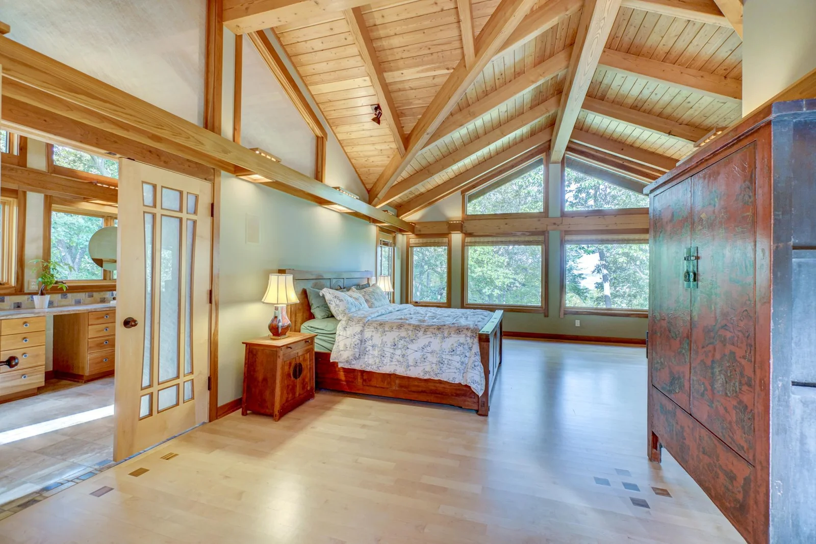 Primary suite with wall of windows looking out to the lake