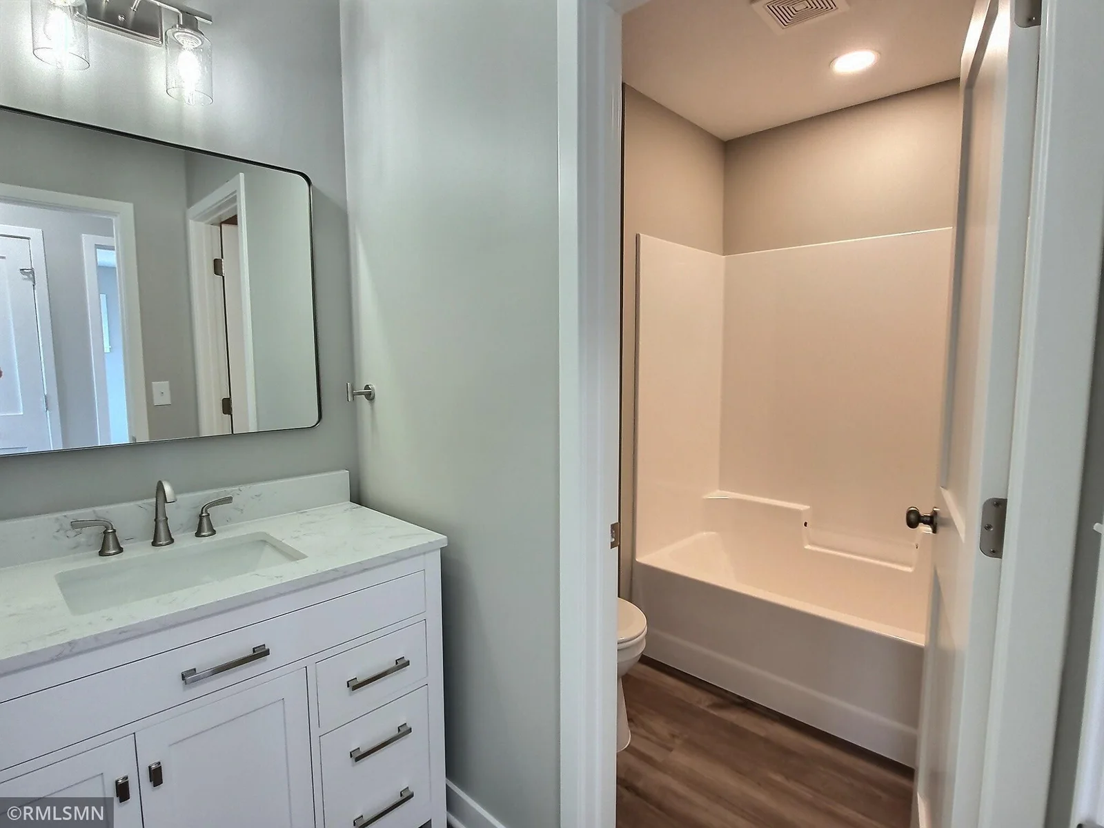 The upper level bath is located near the 2 other bedrooms. Nice design with sink being separated from the tub and shower. Photo is from builders model home and this is what will be built on the lot.