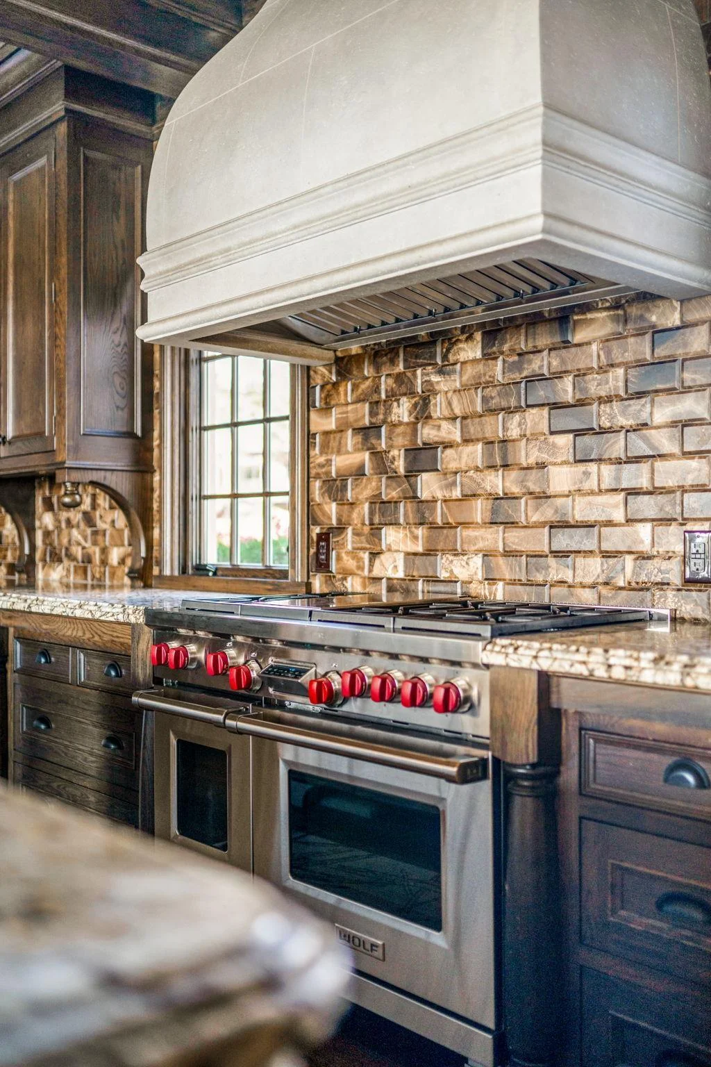 The kitchen is equipped with top-of-the-line appliances, including a gas Wolf stove.
