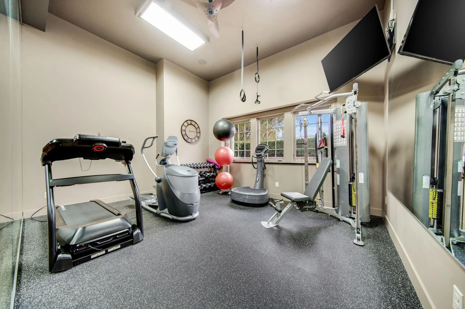 A separate gym area overlooks the court, creating an inspiring workout space. Large windows allow natural light to flood in, enhancing motivation and making exercise enjoyable.