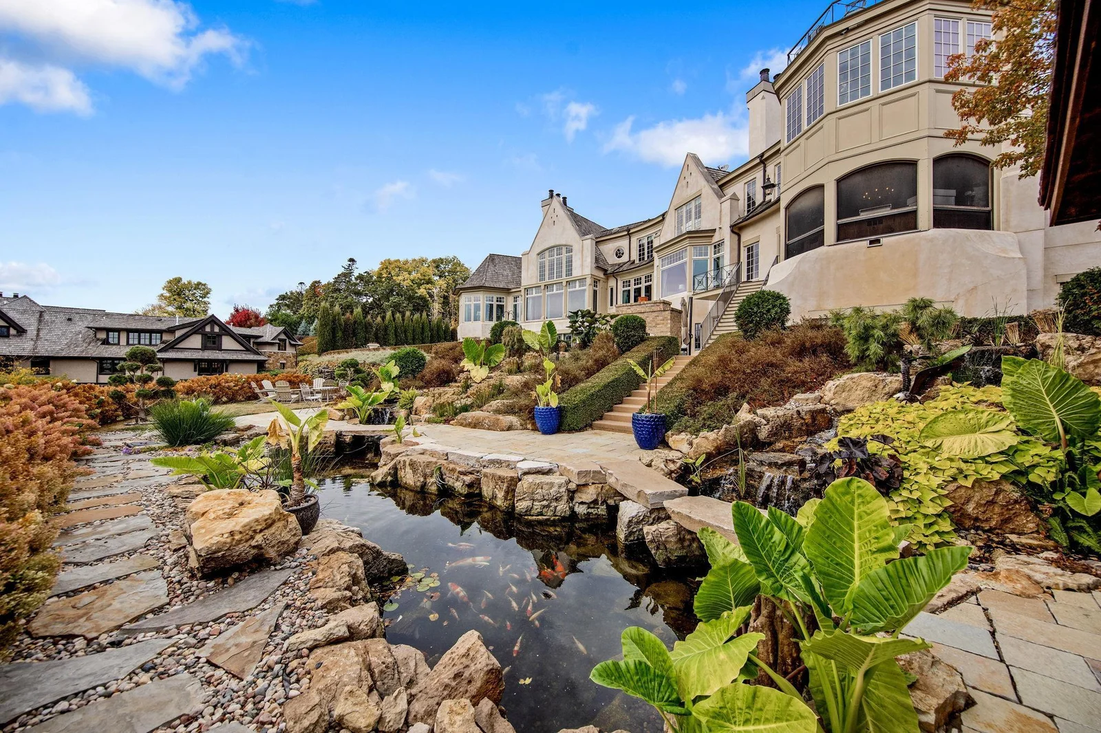Outside landscaping architect TOPO, LLC. created serene privacy with apple trees, koi pond, and waterfalls.