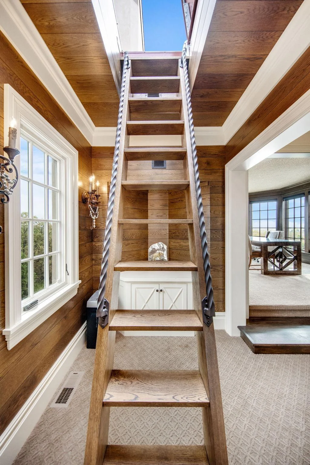 The office features a charming ship's ladder that adds a unique architectural element, leading to the upstairs conservatory deck.