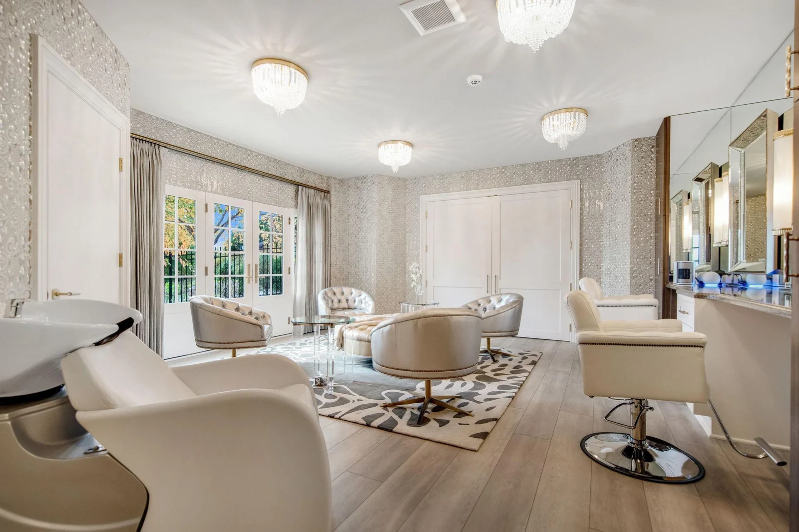 The salon area is a luxurious retreat and the perfect space for pampering! Featuring a washing station, a cozy sitting area, and dressing room. This salon seamlessly opens up to the outdoor pool area.