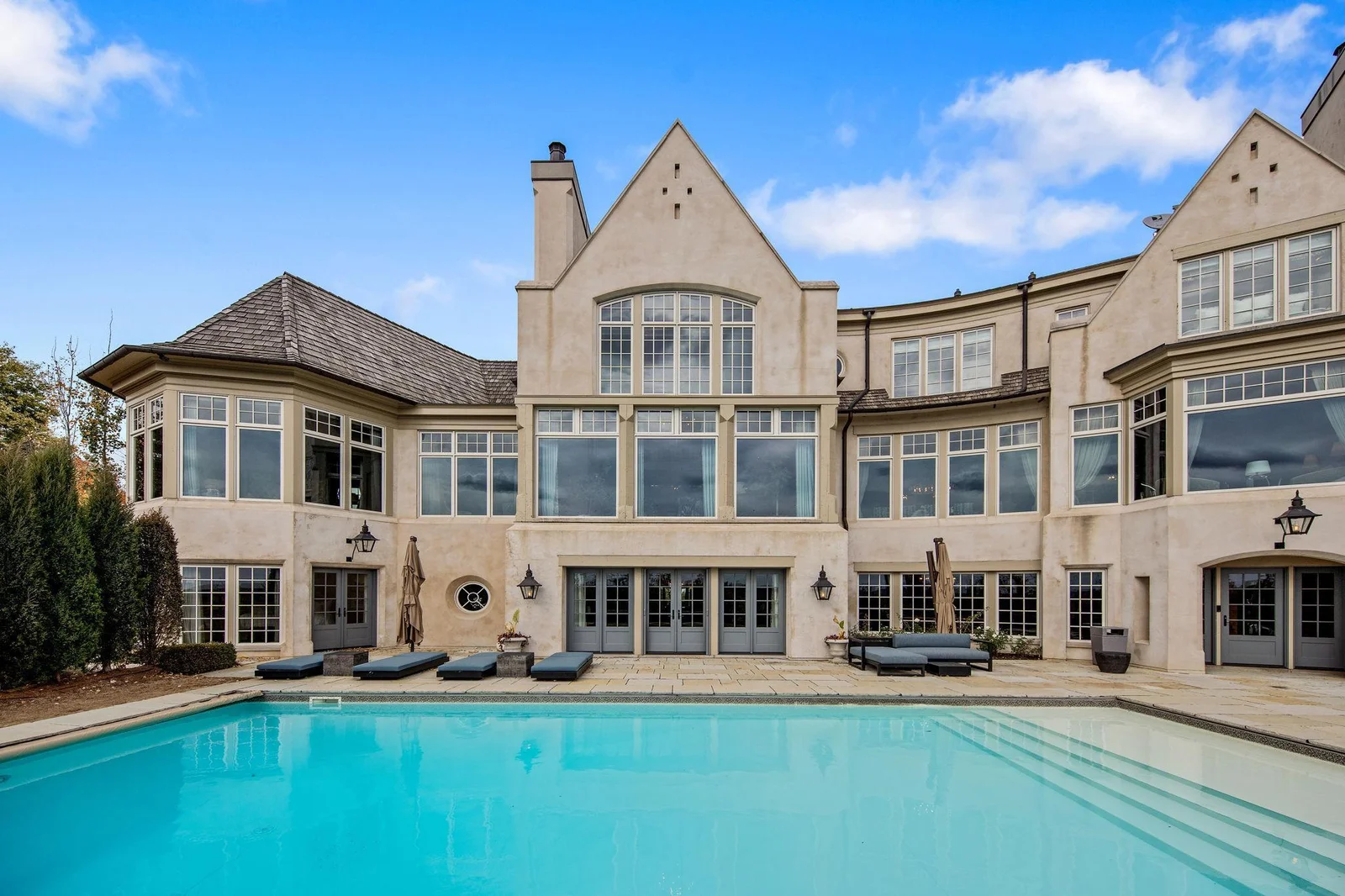 Multiple doors lead seamlessly from the lower level of the home to the pool deck, ensuring easy access and a smooth flow between indoor and outdoor living.