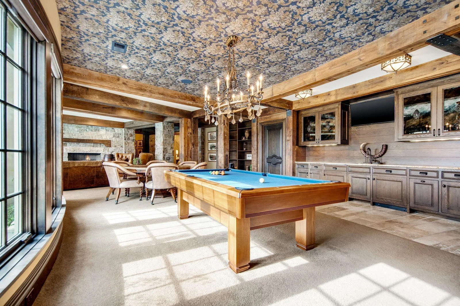 A well-appointed wet bar makes entertaining a breeze, complete with stylish countertops, seating area, and pool table!