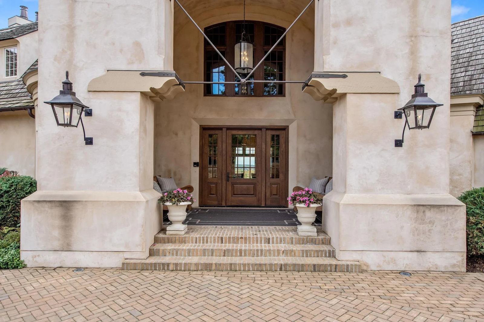The grand archways with gas lanterns welcome you into French Country Charm.