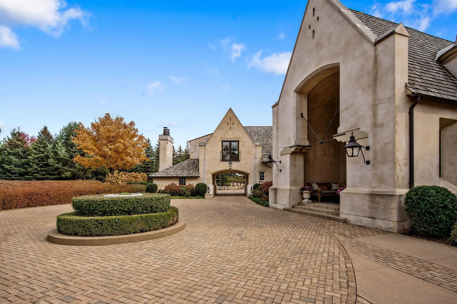Welcome Home to your winding paver driveway, flanked by lush landscaping, and elegant gas lanterns.