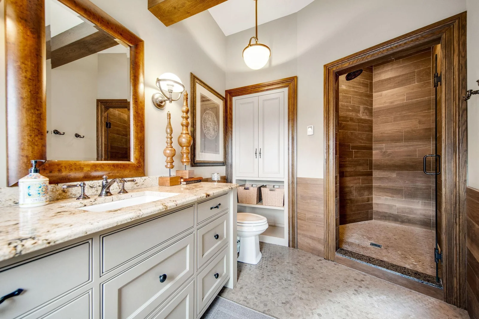 Leading into a private bathroom, this space is thoughtfully designed. The bathroom features a spacious walk-in shower, complemented by bold tile choices.