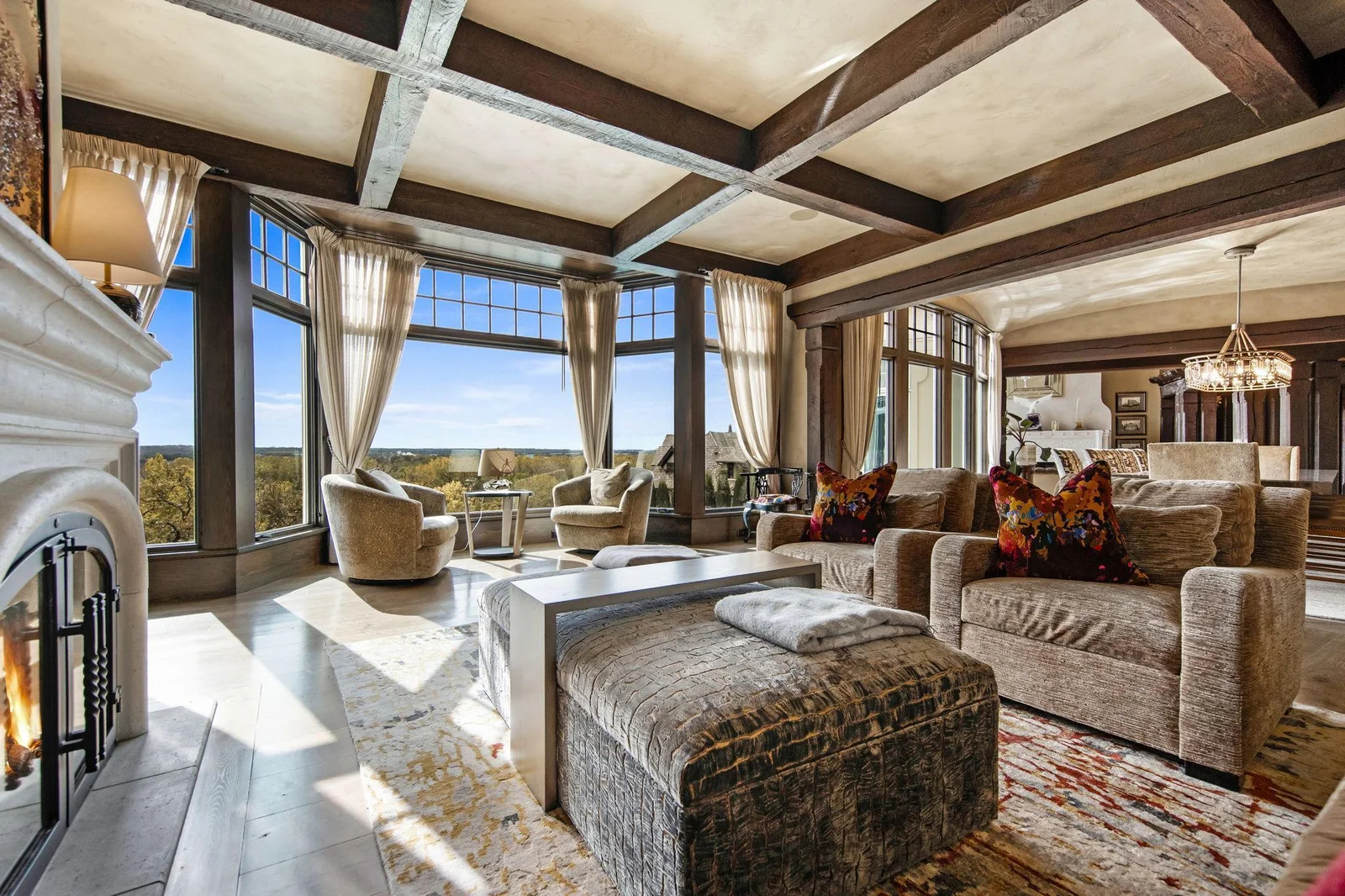 Off the dining room, a cozy sitting room beckons, featuring a charming wood fireplace that adds warmth and a touch of elegance.