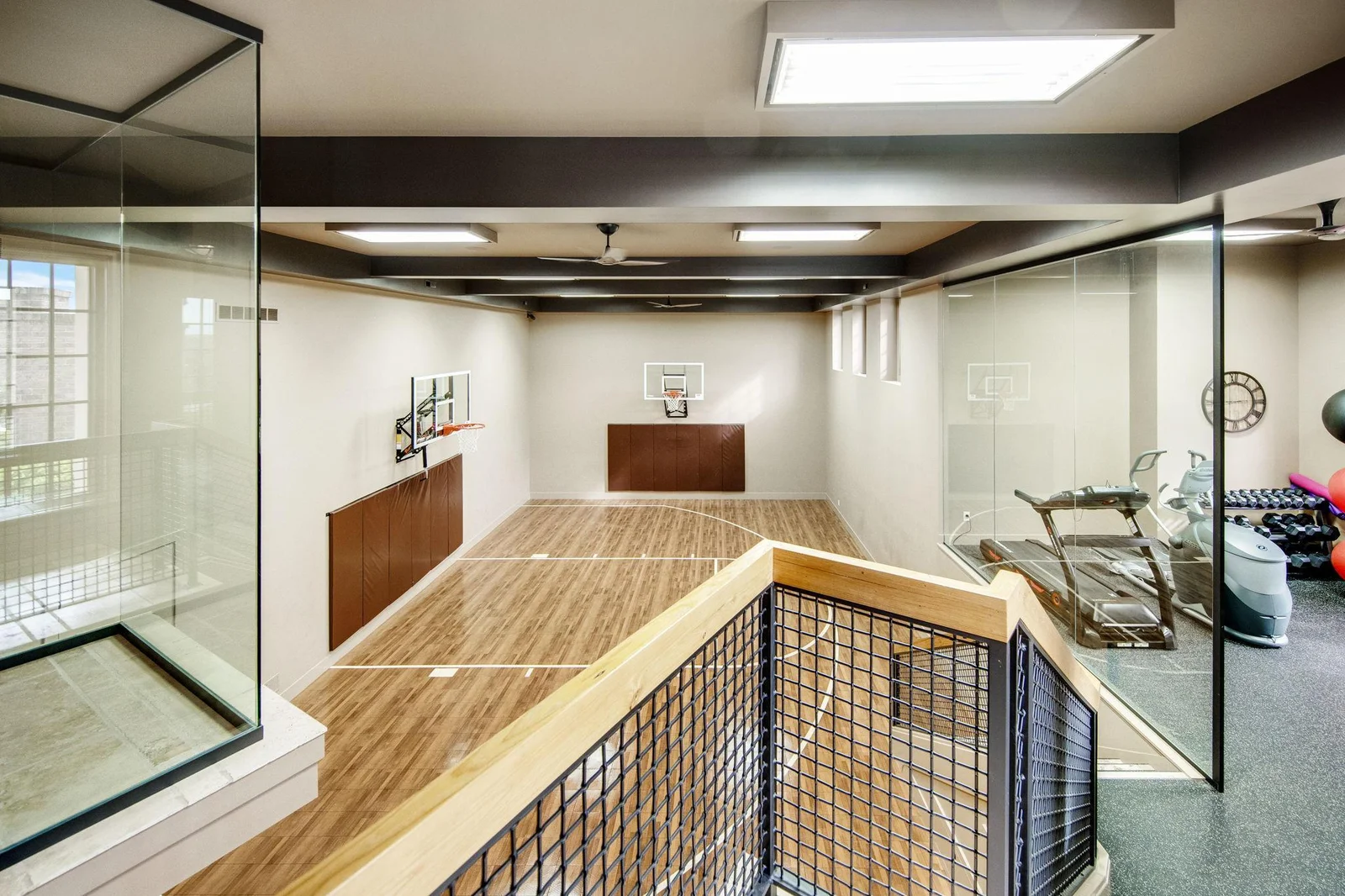 The full sport court is a stunning feature, enclosed by glass walls.