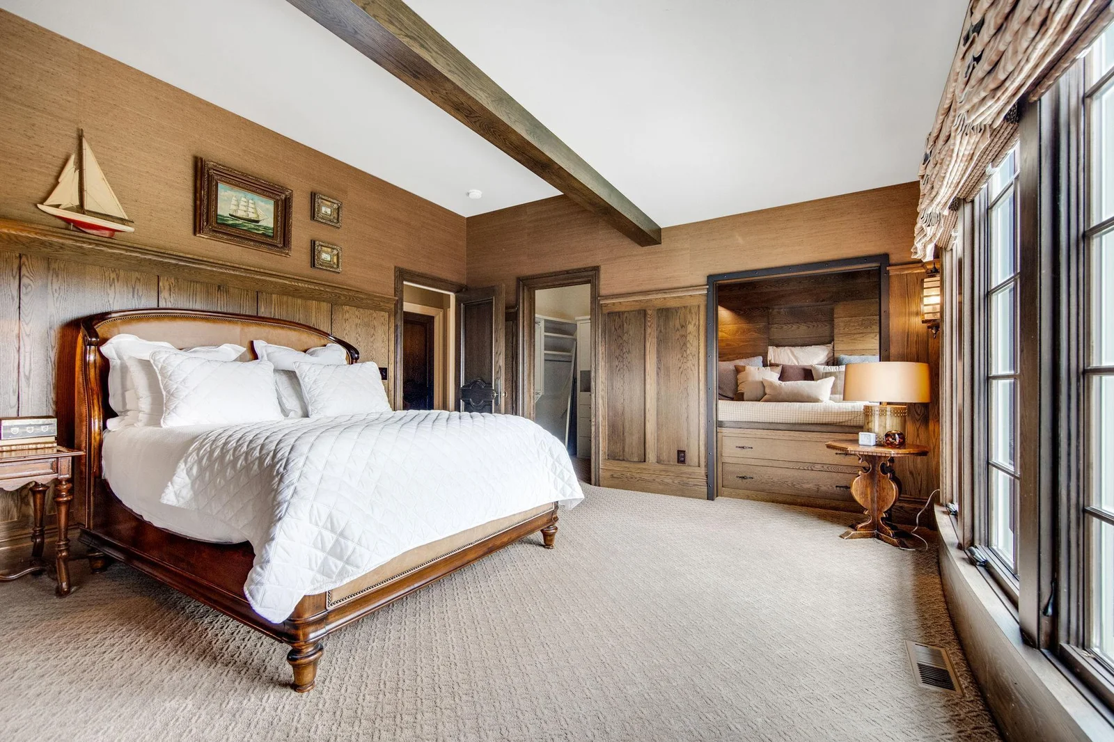 The 3rd upper level bedroom is a warm and inviting space, characterized by rich wood tones that create a cozy, rustic atmosphere. A built-in reading nook is the centerpiece of this bedroom.