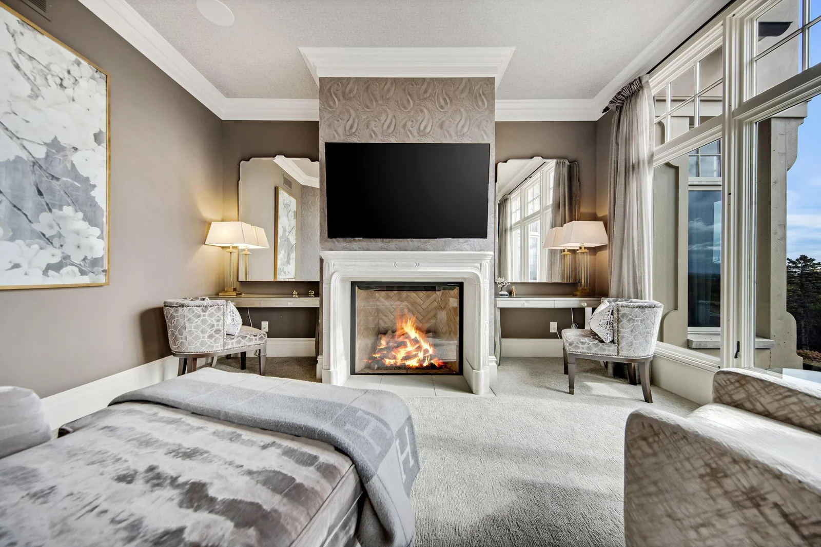 Off the primary is a cozy sitting room, complete with its own fireplace, creating a perfect nook for relaxation, whether you're enjoying a morning coffee or winding down in the evening.