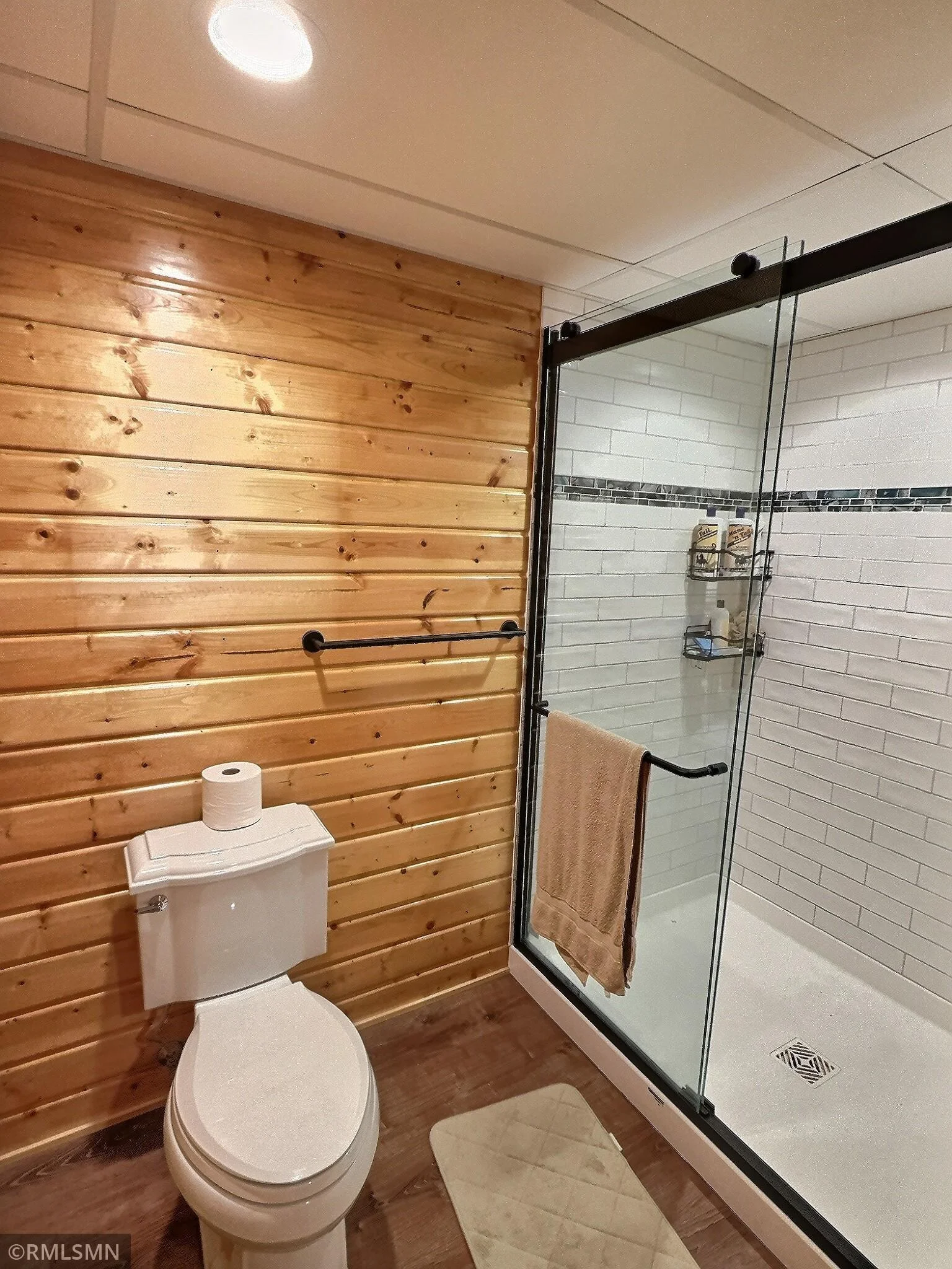 Lower level bathroom with fantastic design elements throughout including wood accents and glass shower.