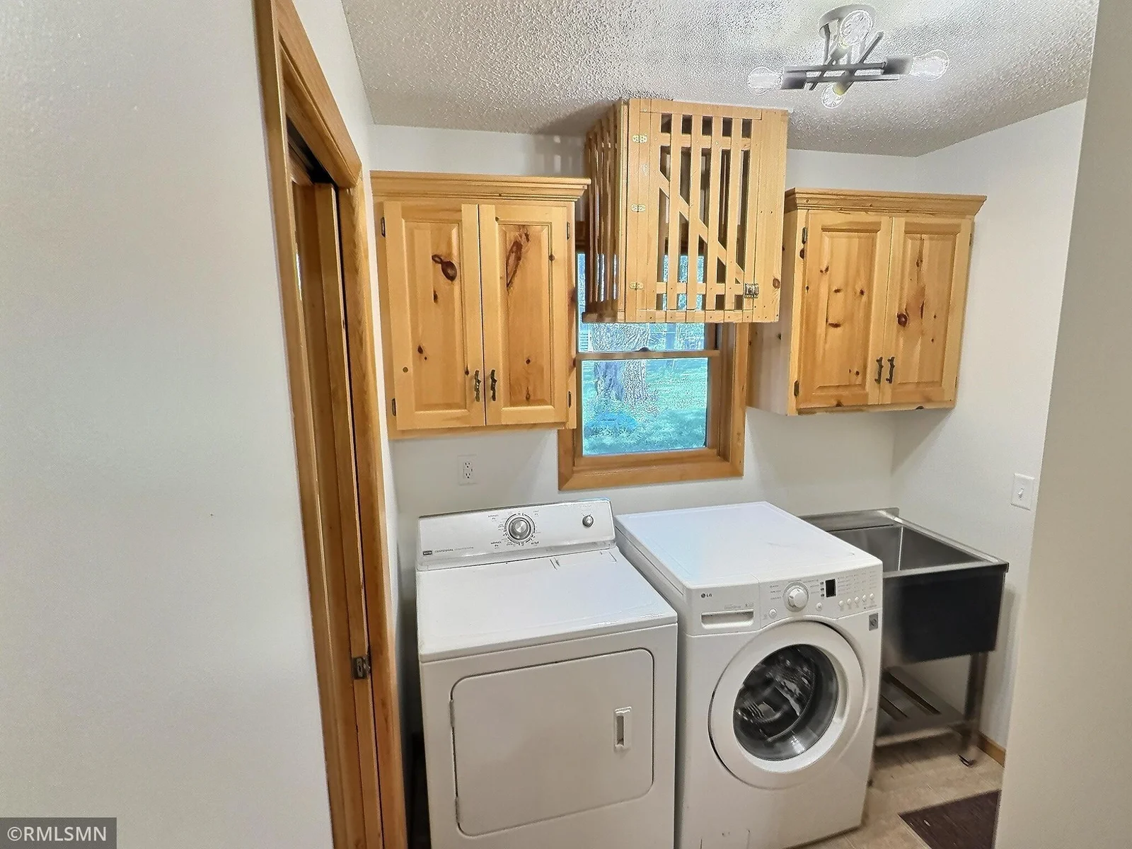 Just off the kitchen is a laundry room complete with a sink, to the right is the garage, to the left a half bathroom.
