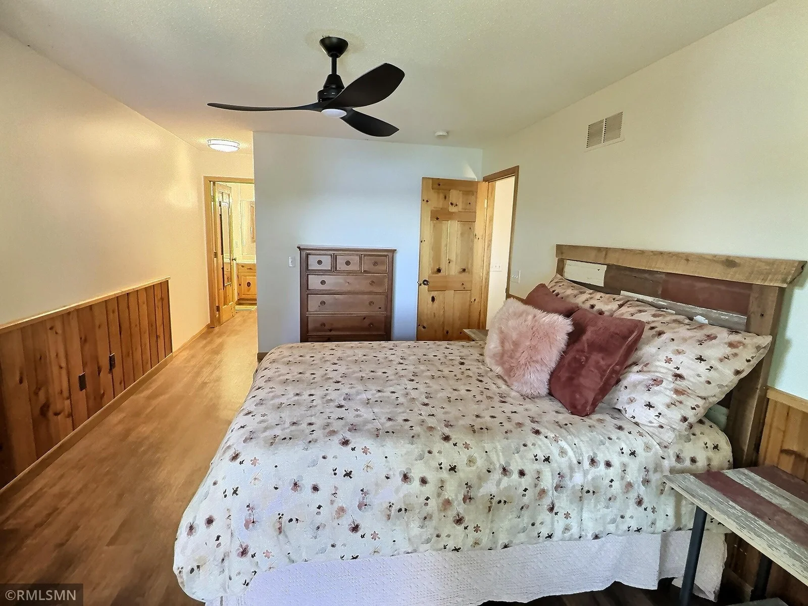 The primary suite is complete with ceiling fan, wood accents, walk-in closet, and wonderful natural light.