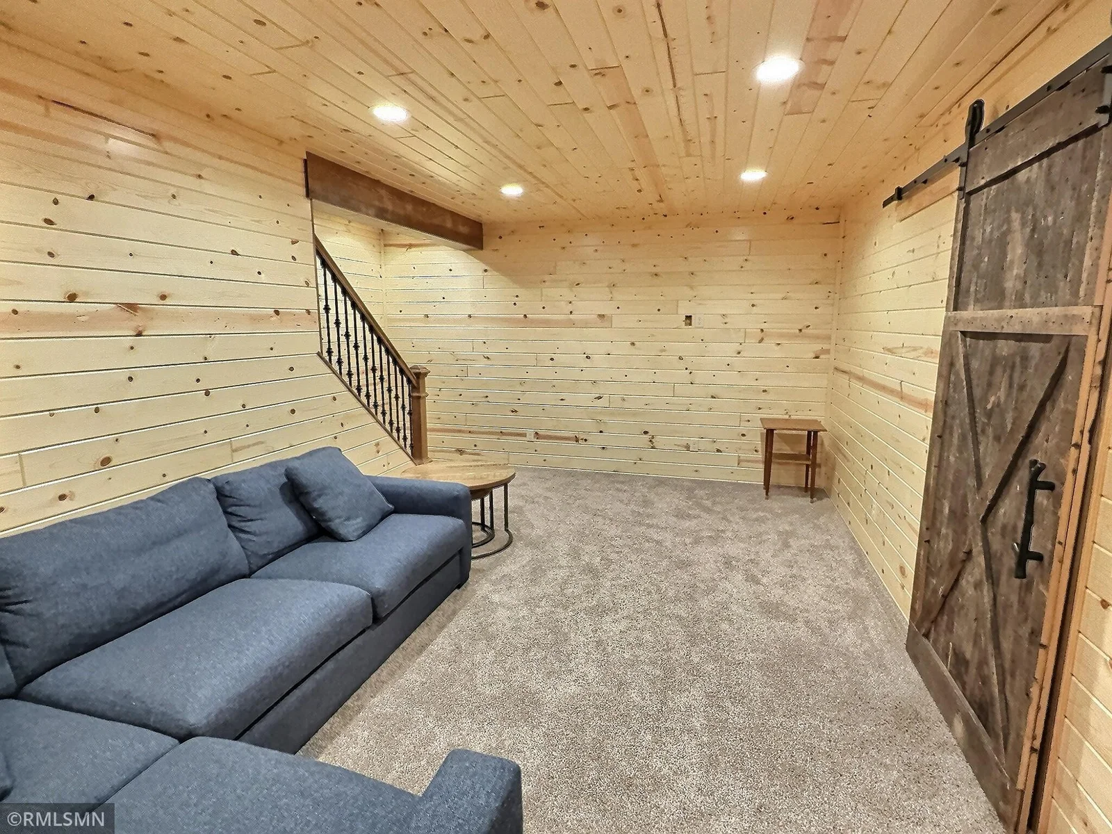 The lower level family room features natural wood work and sliding barn door that opens to the utility room.