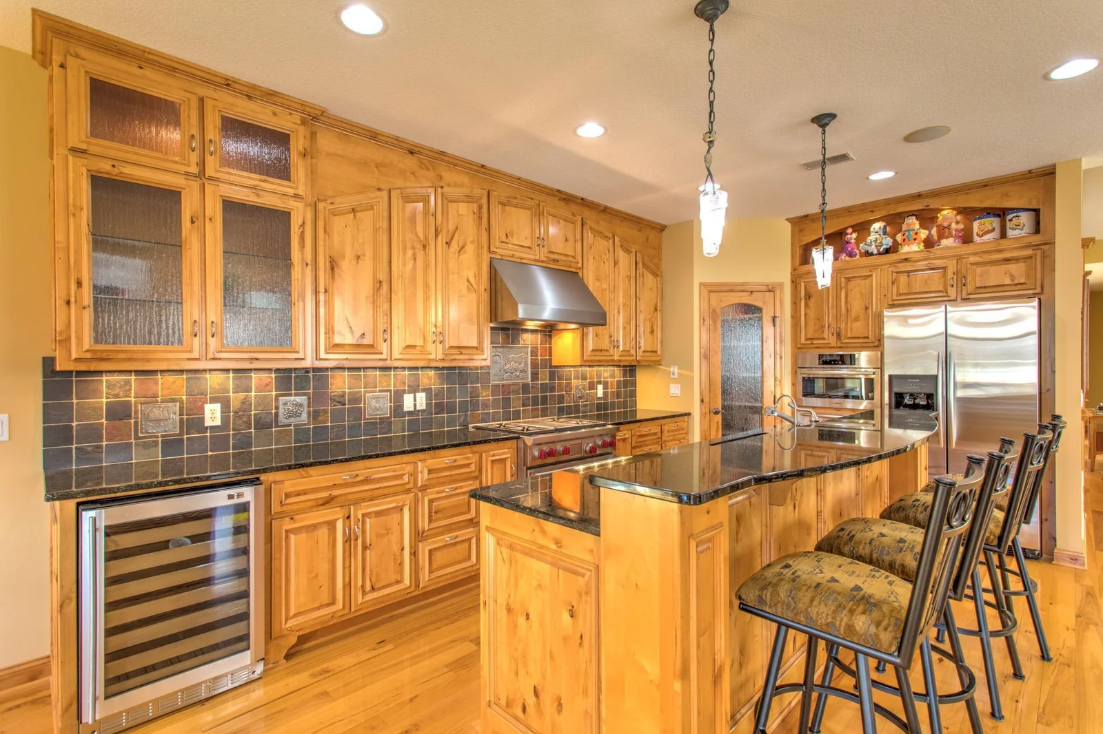 Fantastic gourmet kitchen with custom Alder cabinets, granite tops, and slate tiled backsplash