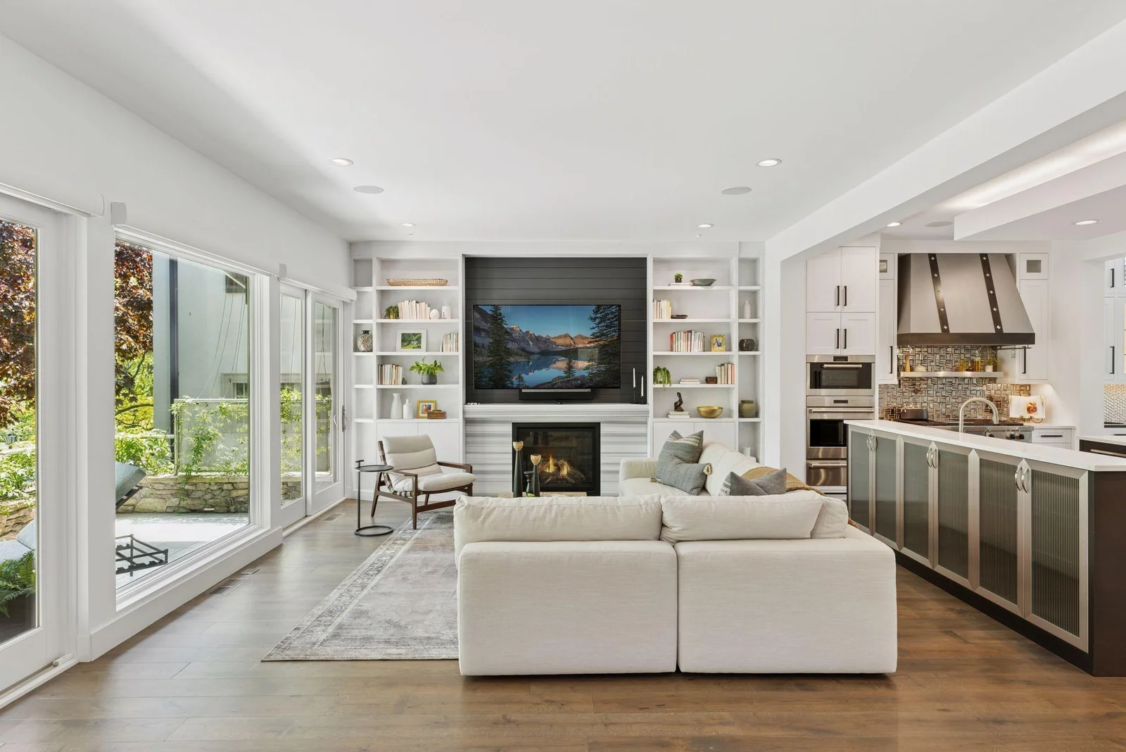Living room open to east facing deck with 2 sliding doors, fireplace and built-in bookcases