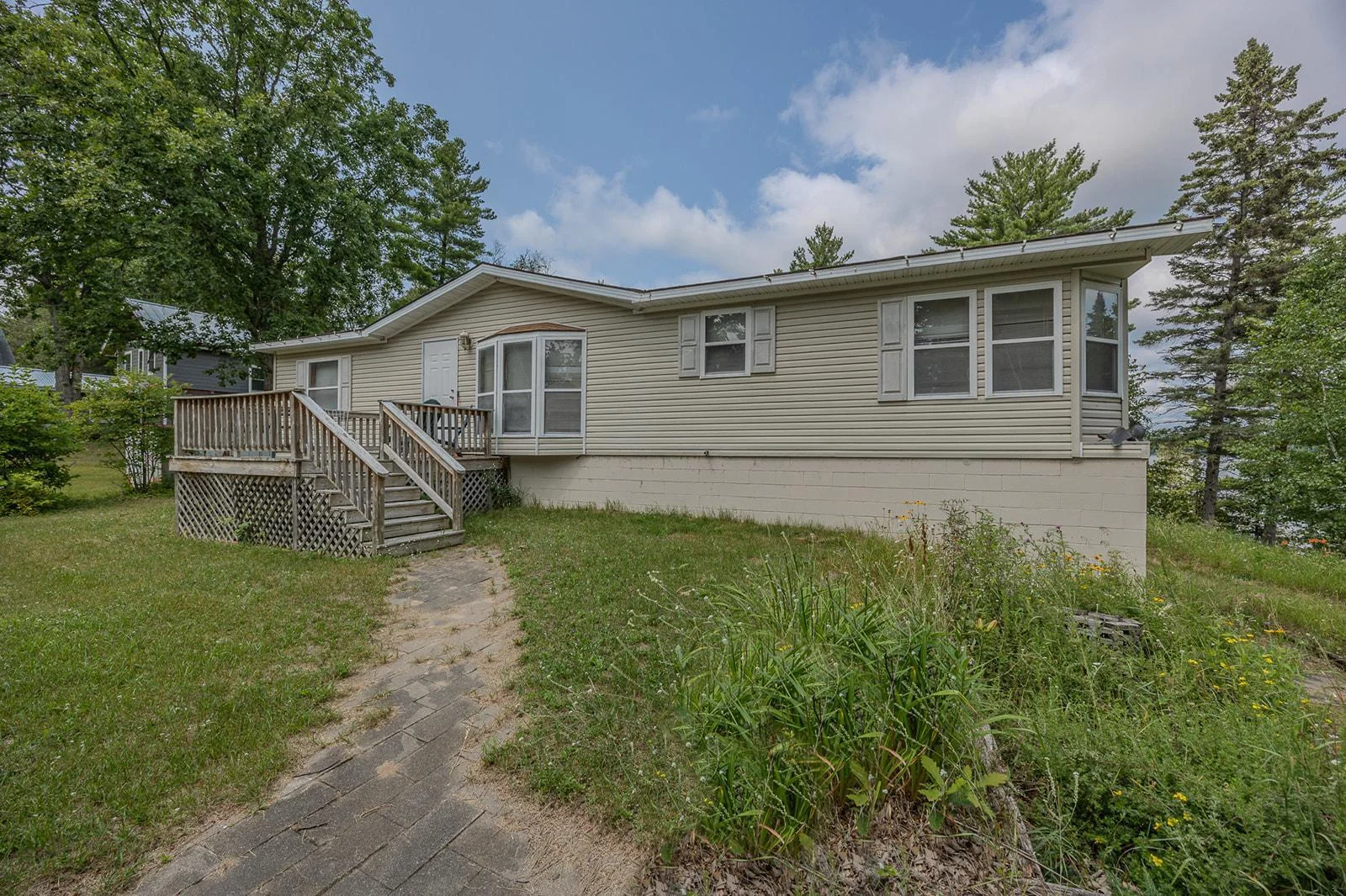 Manufactured home with a block basement on Wabedo Lake selling as is.