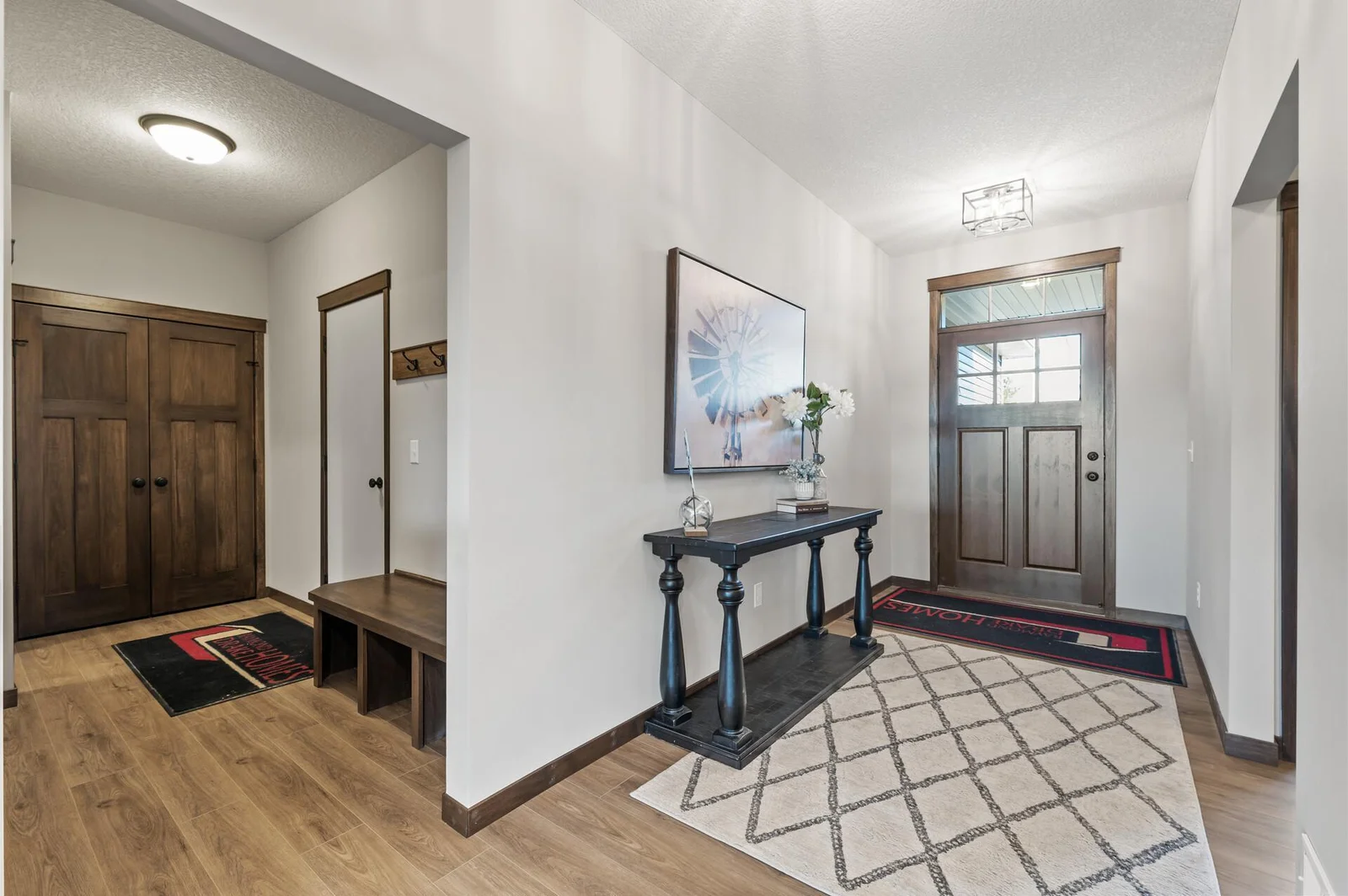 Another view of the foyer area and beautiful 42 inch wide wood front door with transom window stacked above it.