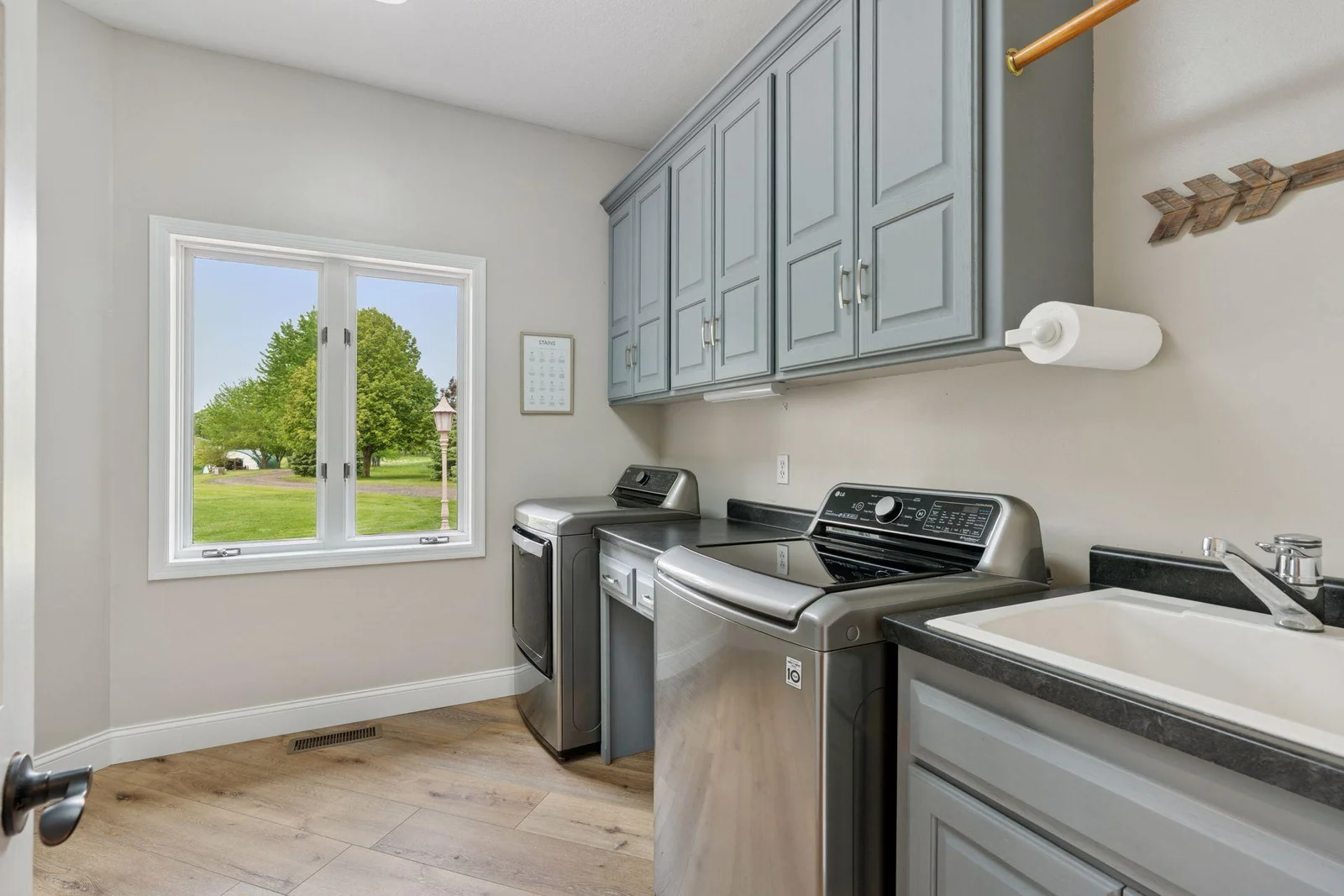 Main Floor Laundry with Cabinet Storage and Laundry Tub