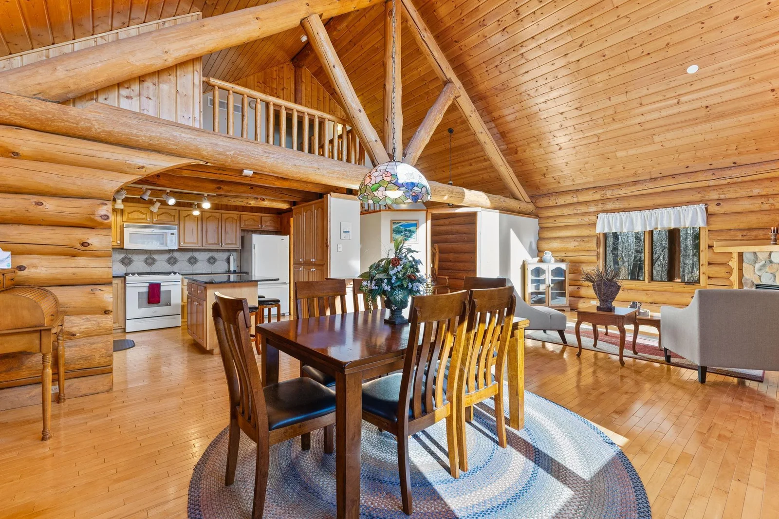 The vaulted ceiling enhances the sense of grandeur, while the loft area adds a unique touch and additional living space. This area seamlessly integrates the dining room, kitchen, and living room, creating a harmonious flow throughout.