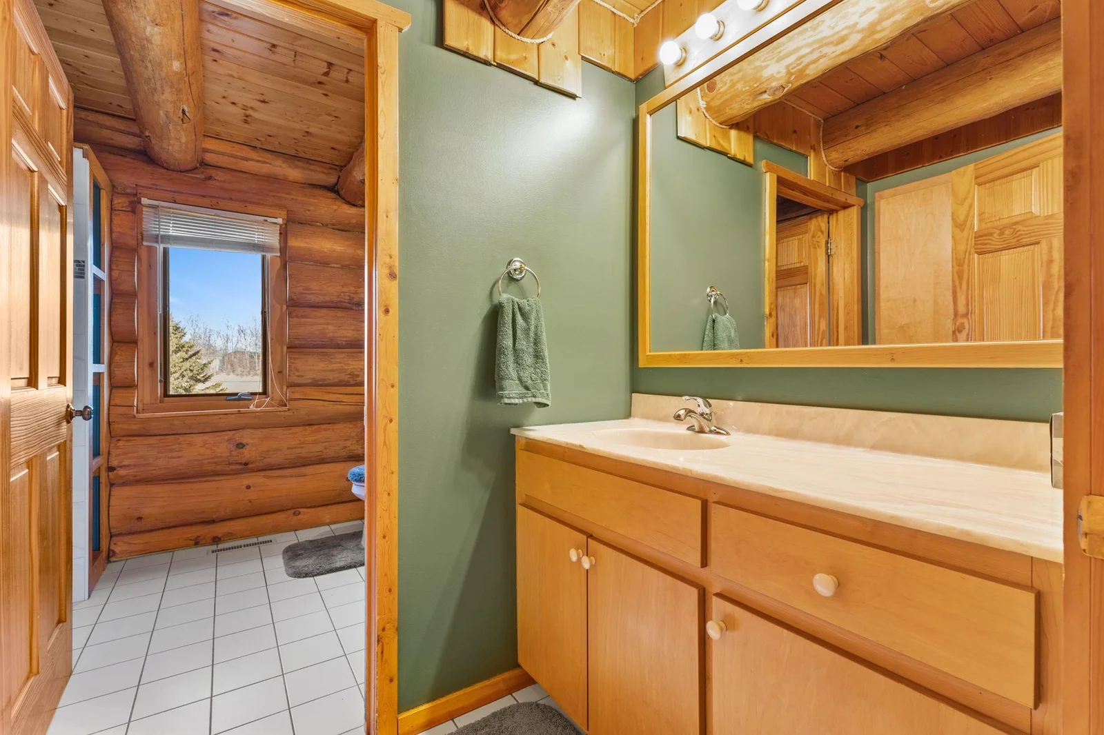 This main floor full bath features a large vanity and ceramic floor. A touch of rustic charm to your home with this stunning log beams ceiling.
