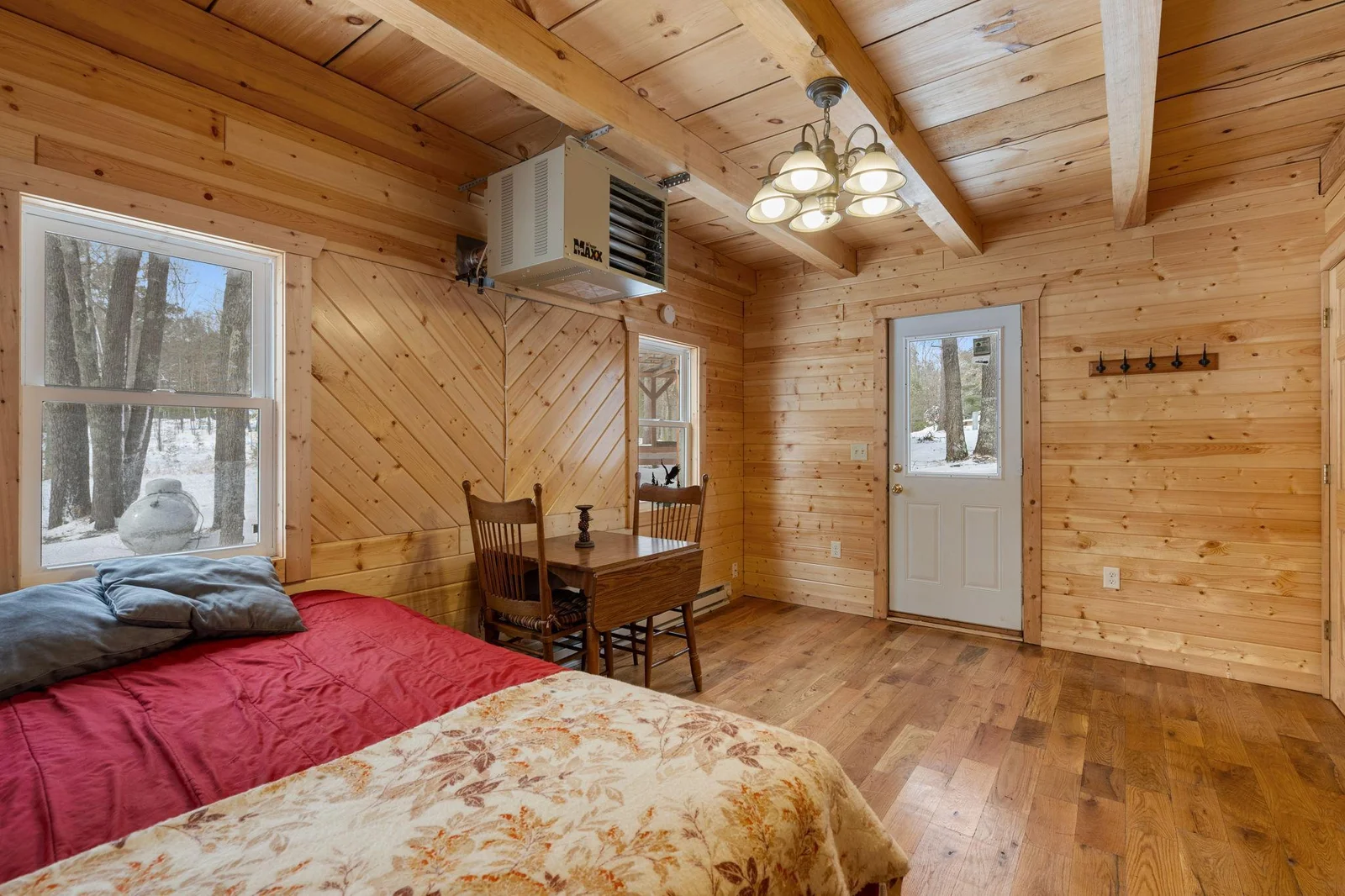 Main floor bedroom with door leading out to the back of cabin.