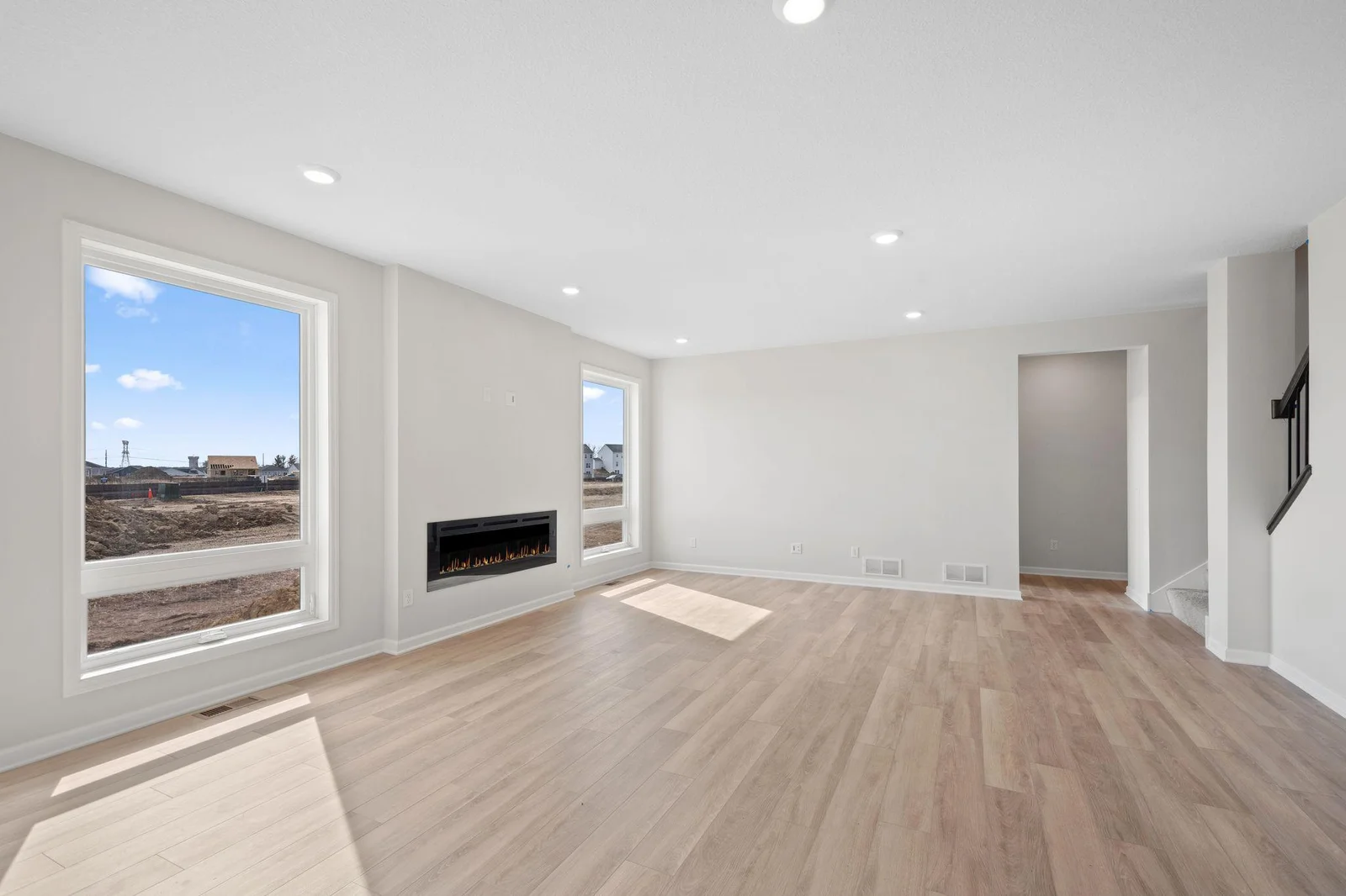 WOW!  Enjoy this generous living area bathed in natural light, highlighted by expansive windows and a modern electric fireplace for year-round ambiance.