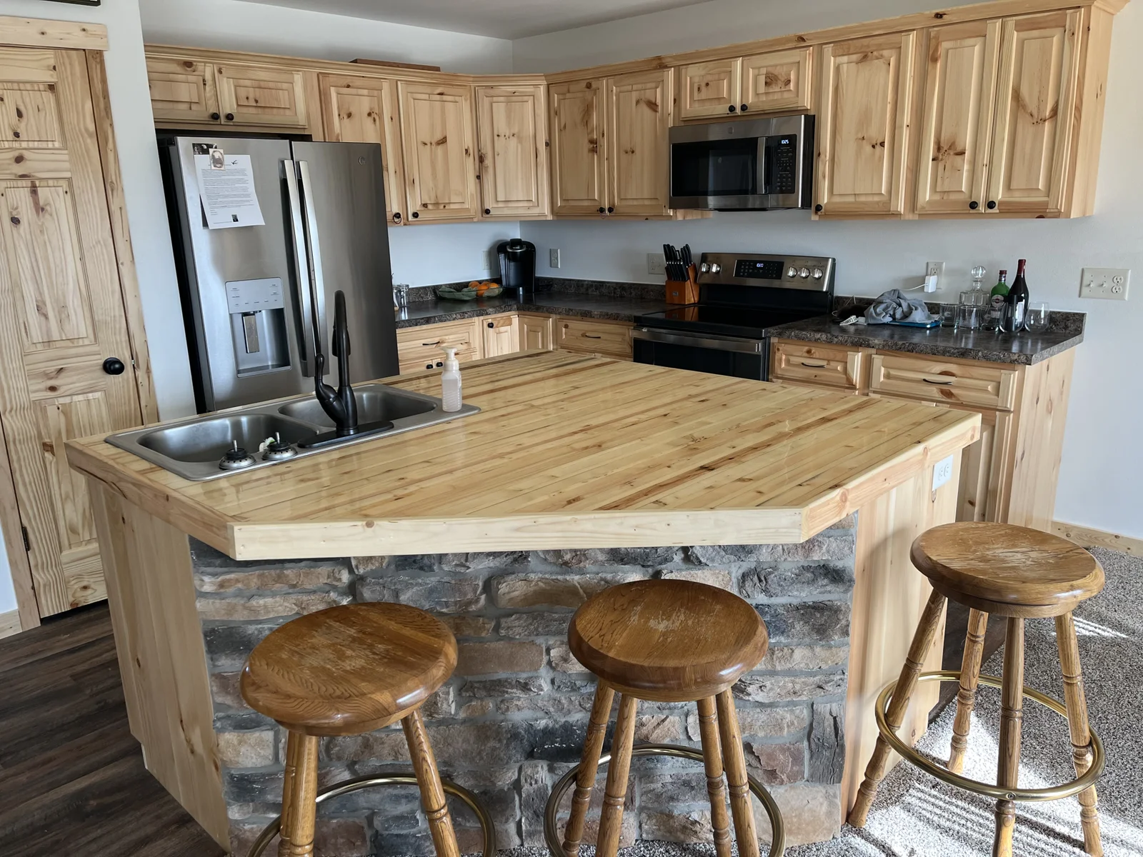 The kitchen features hardwood floors and beautiful cabinets and a kitchen island.