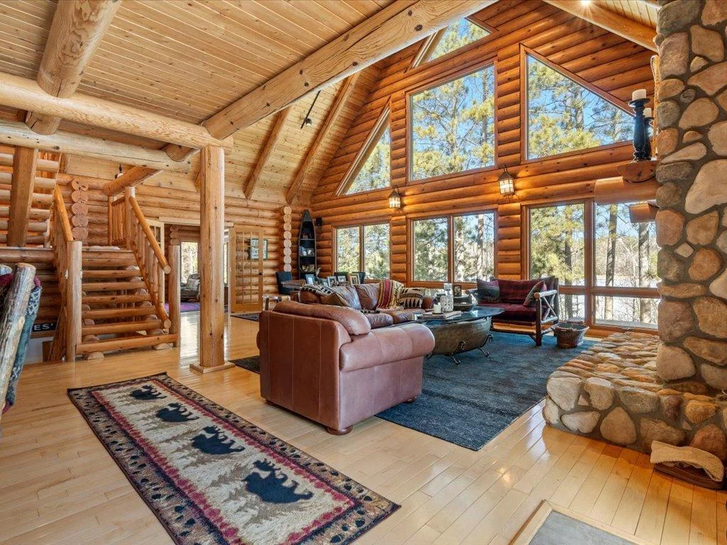 Open design living room with maple hard-wood flooring and rock fireplace.