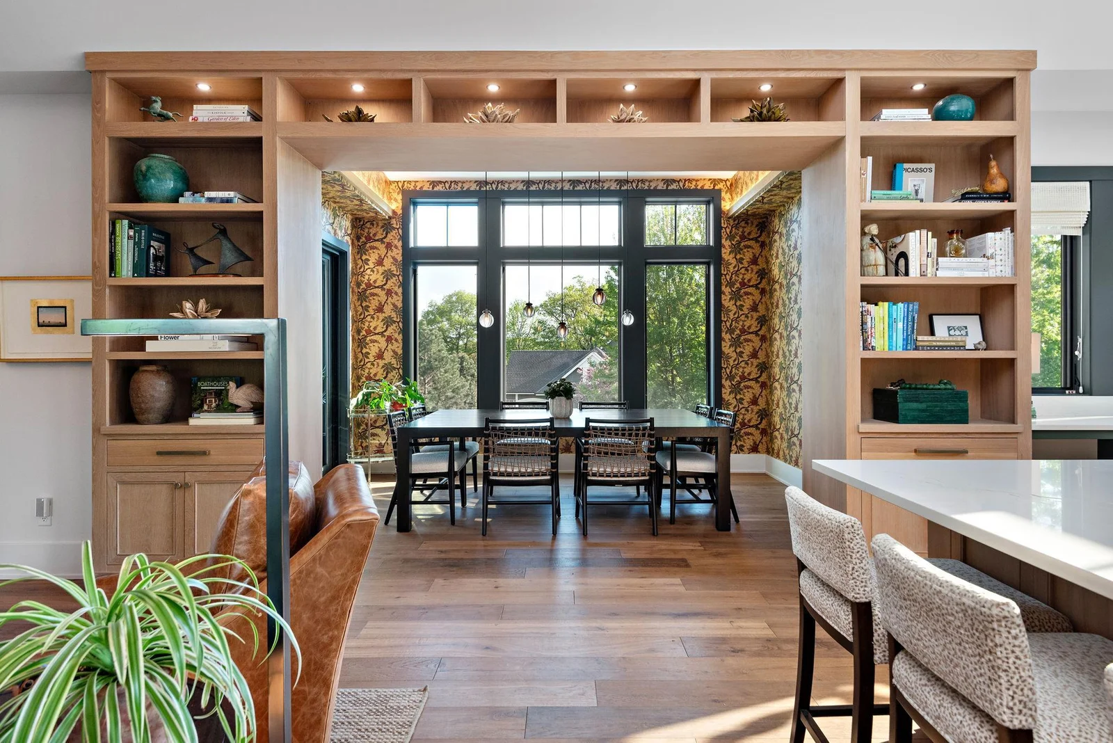 Here floor-to-ceiling shelving as a room divider creates a functional and visually appealing partition that optimize space utilization and enhance the overall design aesthetic. These shelves offer a stylish and functional element to the space.
