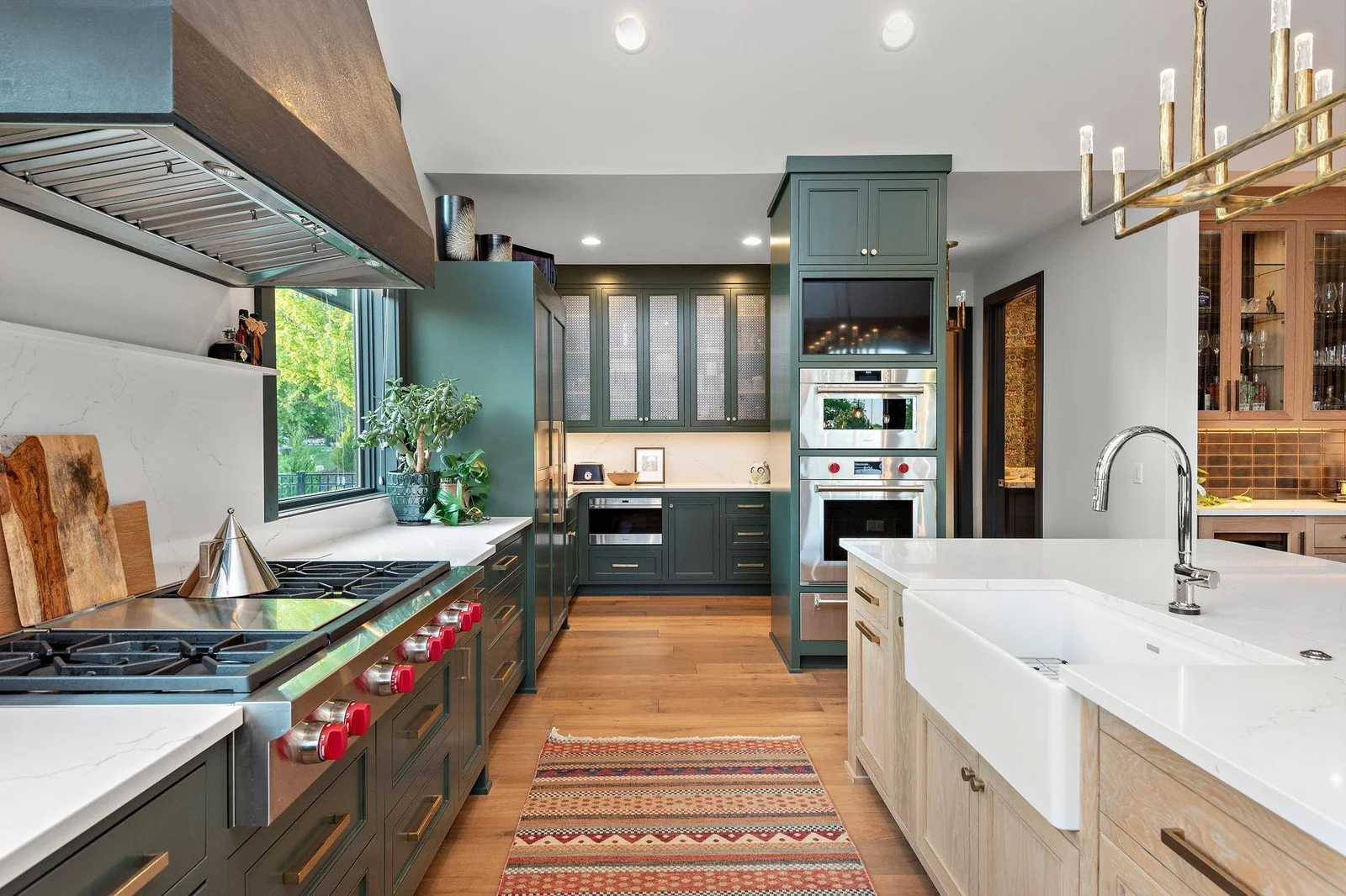 The gourmet kitchen is anchored with a show-stopping range hood and elite upscale appliance suite. Every convenience was considered when designing this world-class kitchen - right down to the added space between the custom cabinetry and the island.
