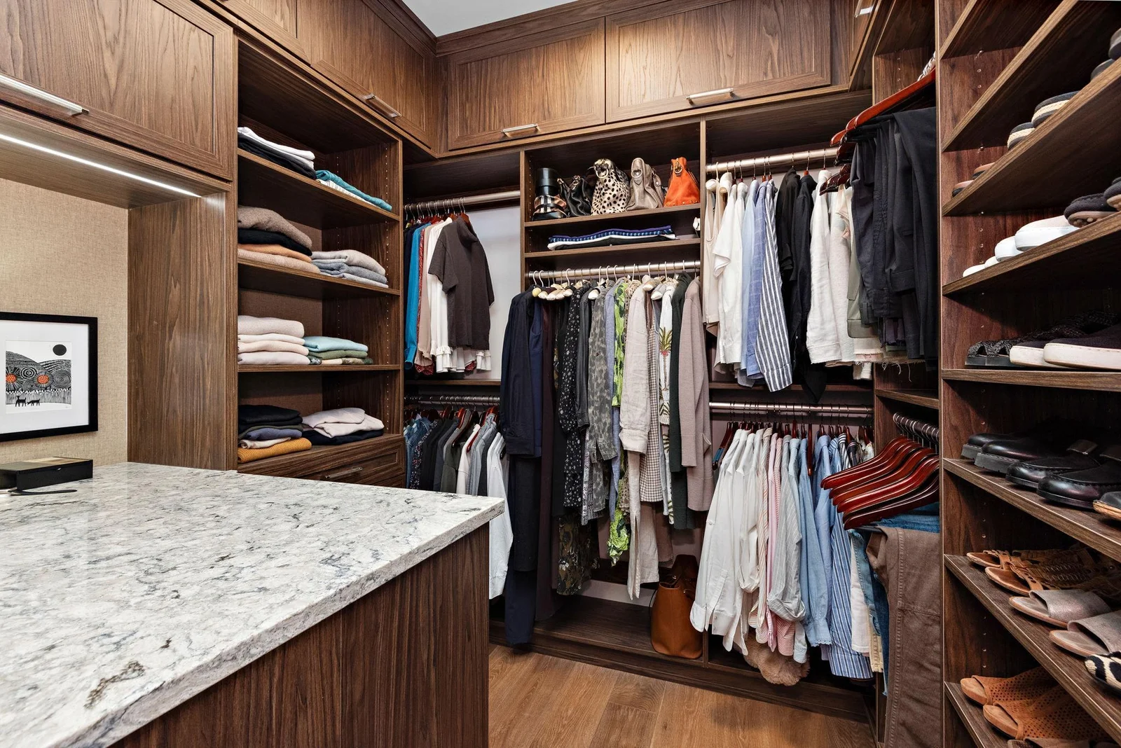 The main floor primary suite closet boasts its own island, skylight, and washer & dryer