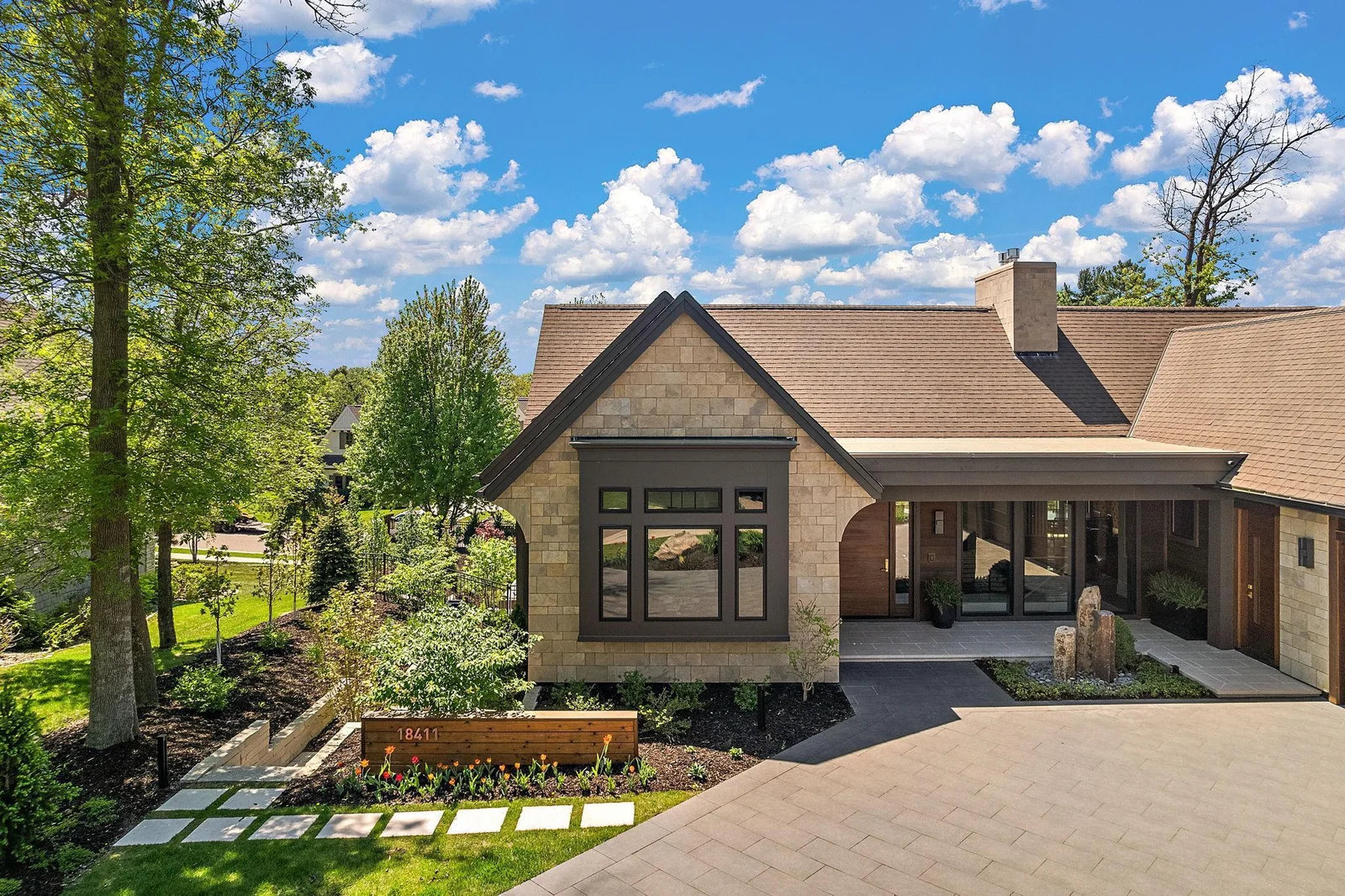 Exterior design elements include 16" x 32" Grestone Renaissance Porcelain Pavers meticulously laid out in a diagonal diamond pattern. Front of home finished in natural limestone & cedar. Sides and rear of home finished in eco-friendly James Hardie.