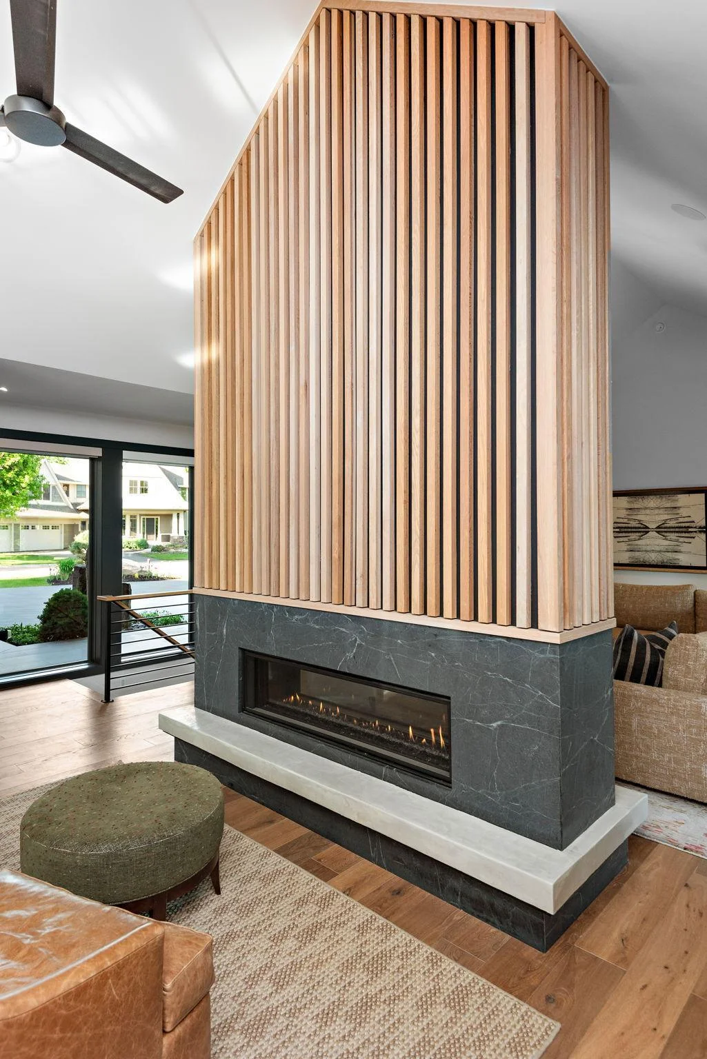 The Gathering Room and Chef's Kitchen are dramatically balanced by the floor-to-ceiling double-sided fireplace cloaked in white oak and balanced by a soap stone surround with concrete hearth. Absolutely stunning!