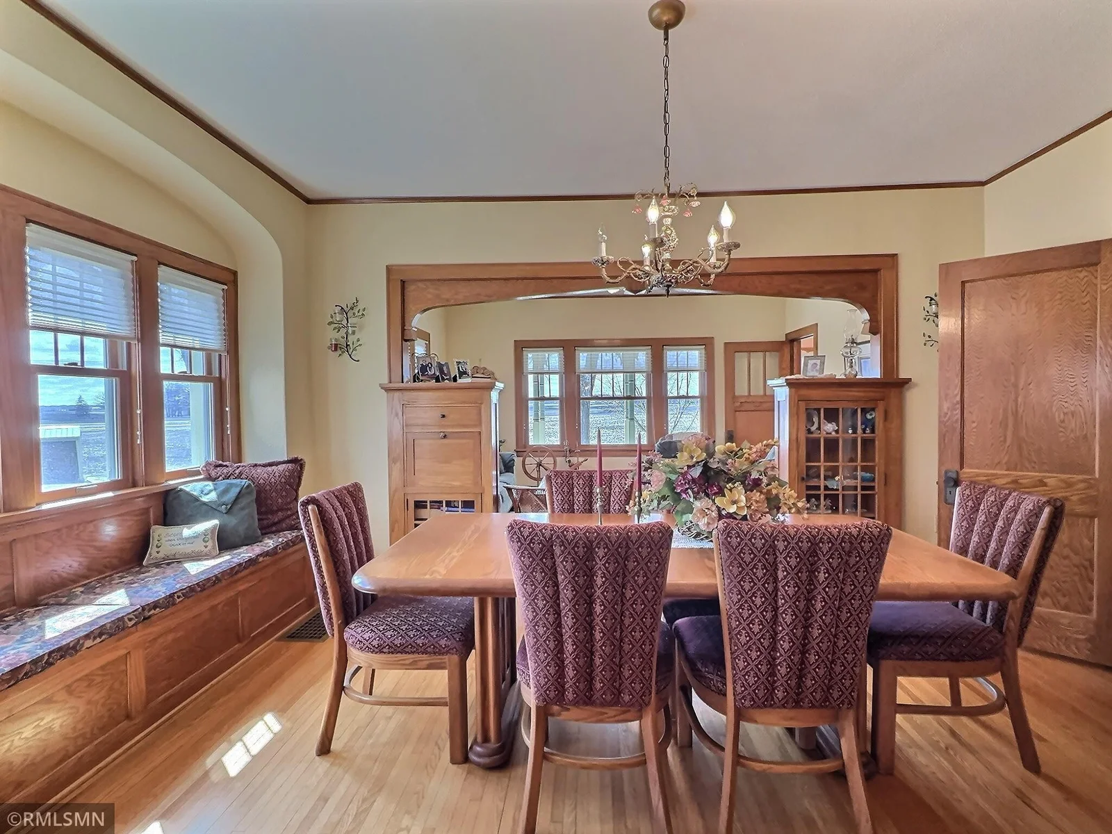 This dining room boasts beautiful woodwork, and original built in original cabinetry and bench. Antique light fixture hangs beautifully above the table.