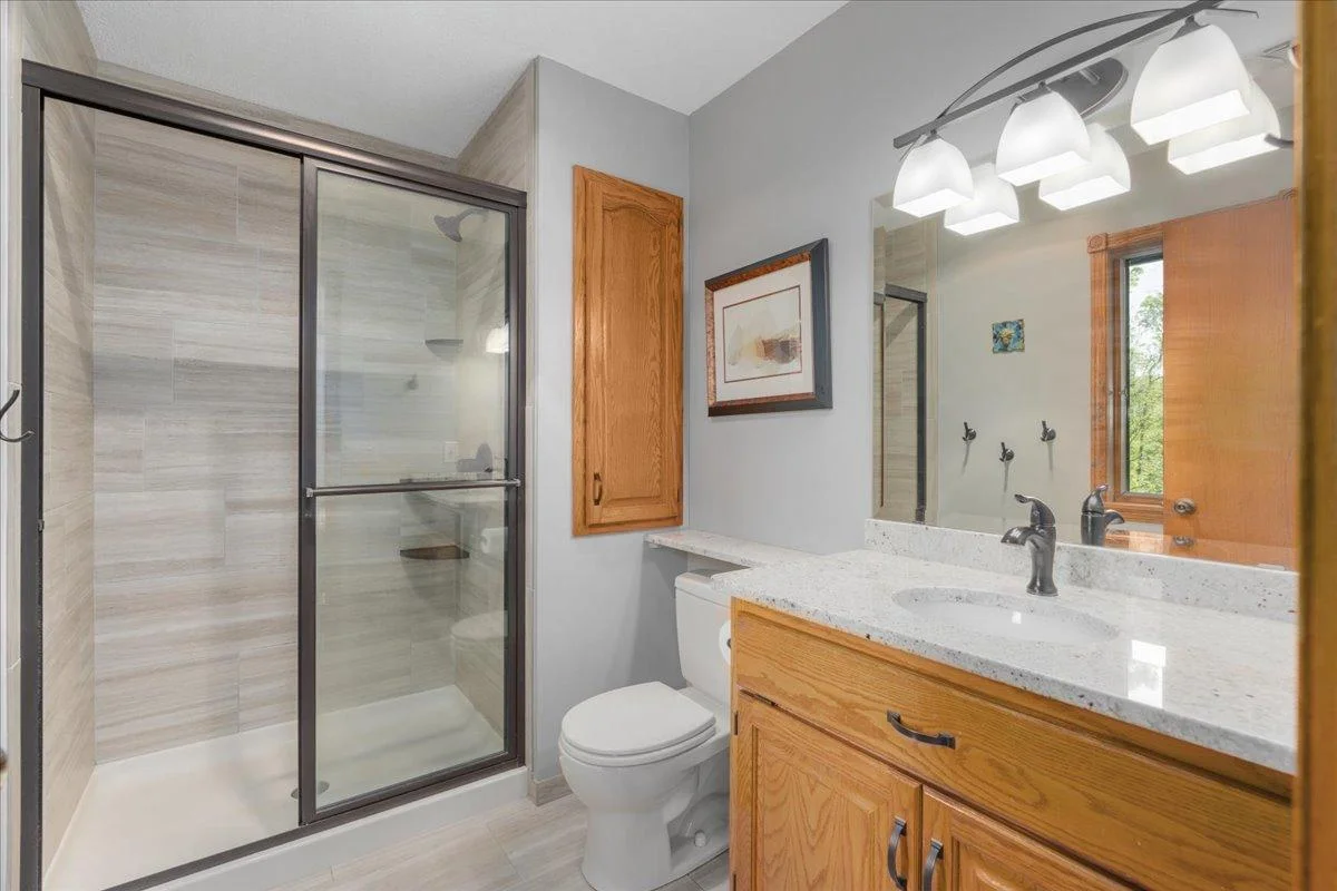 Primary bathroom with walk-in shower, tiled floor and granite countertop